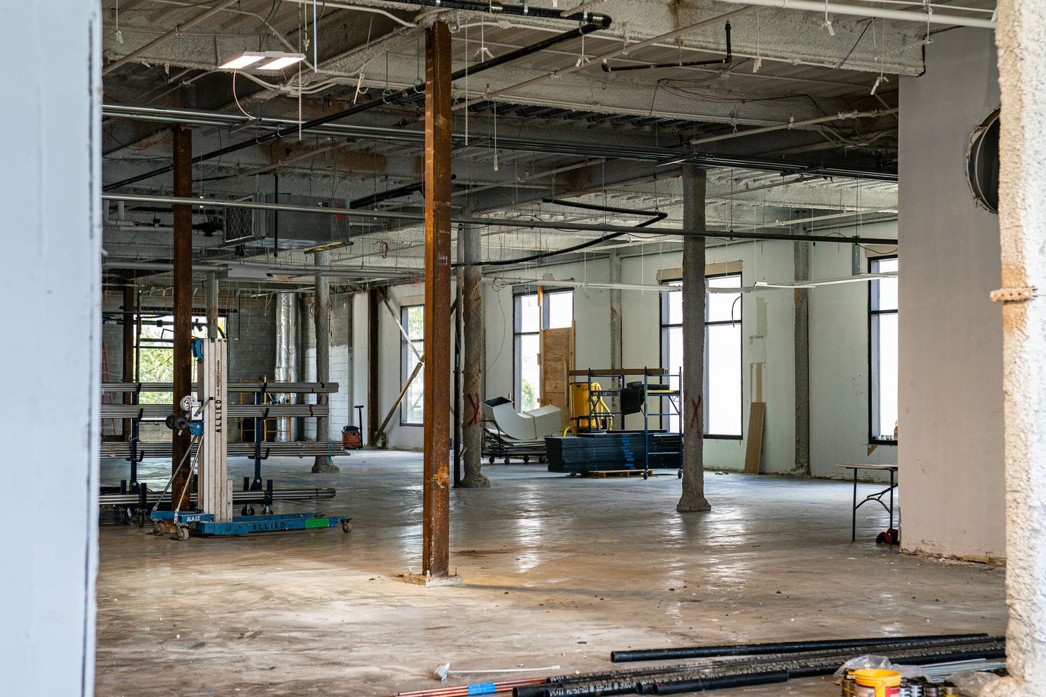 Spacious warehouse interior featuring exposed structural elements and utility installations.