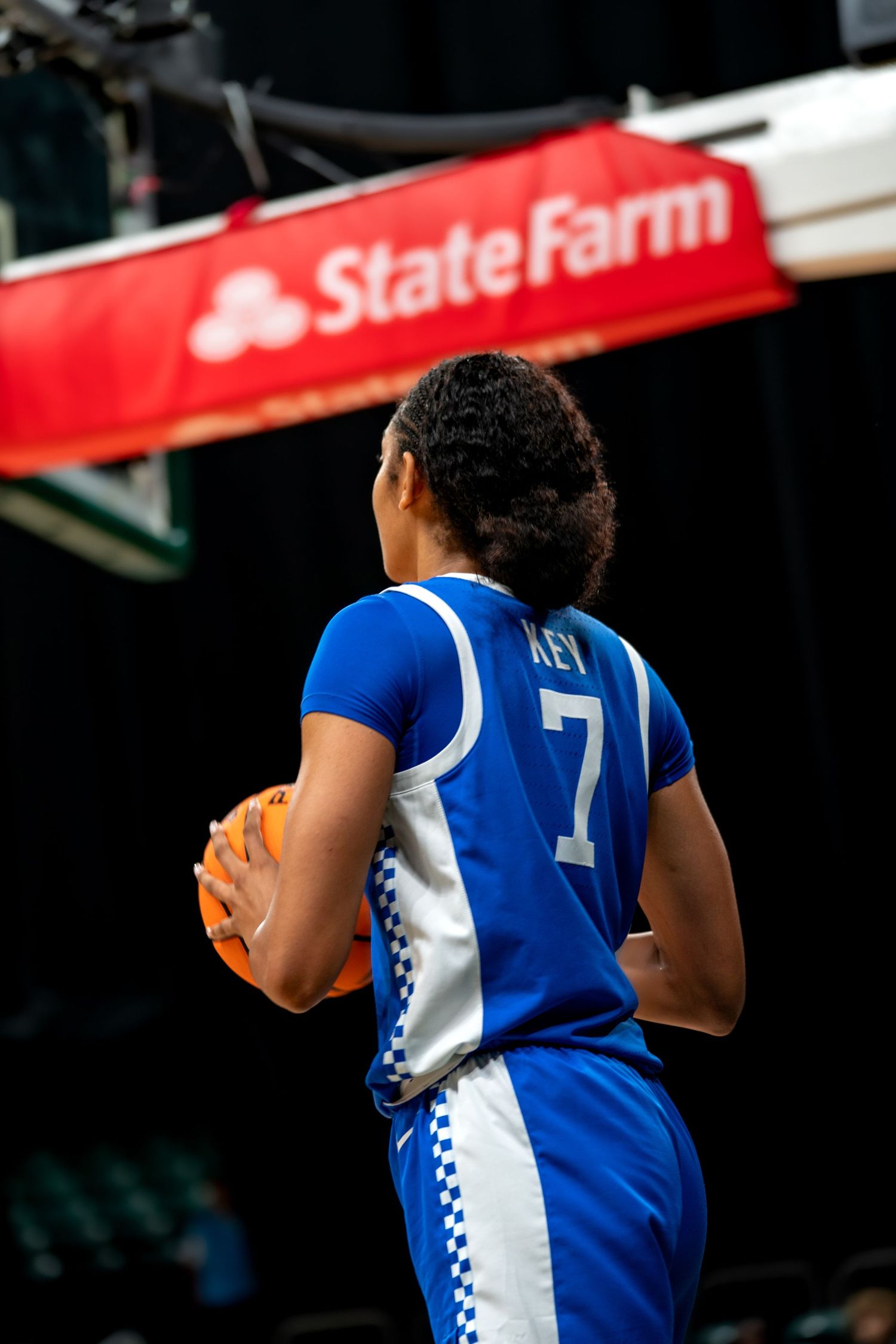 Basketball player in Kentucky blue jersey runs down court during game.