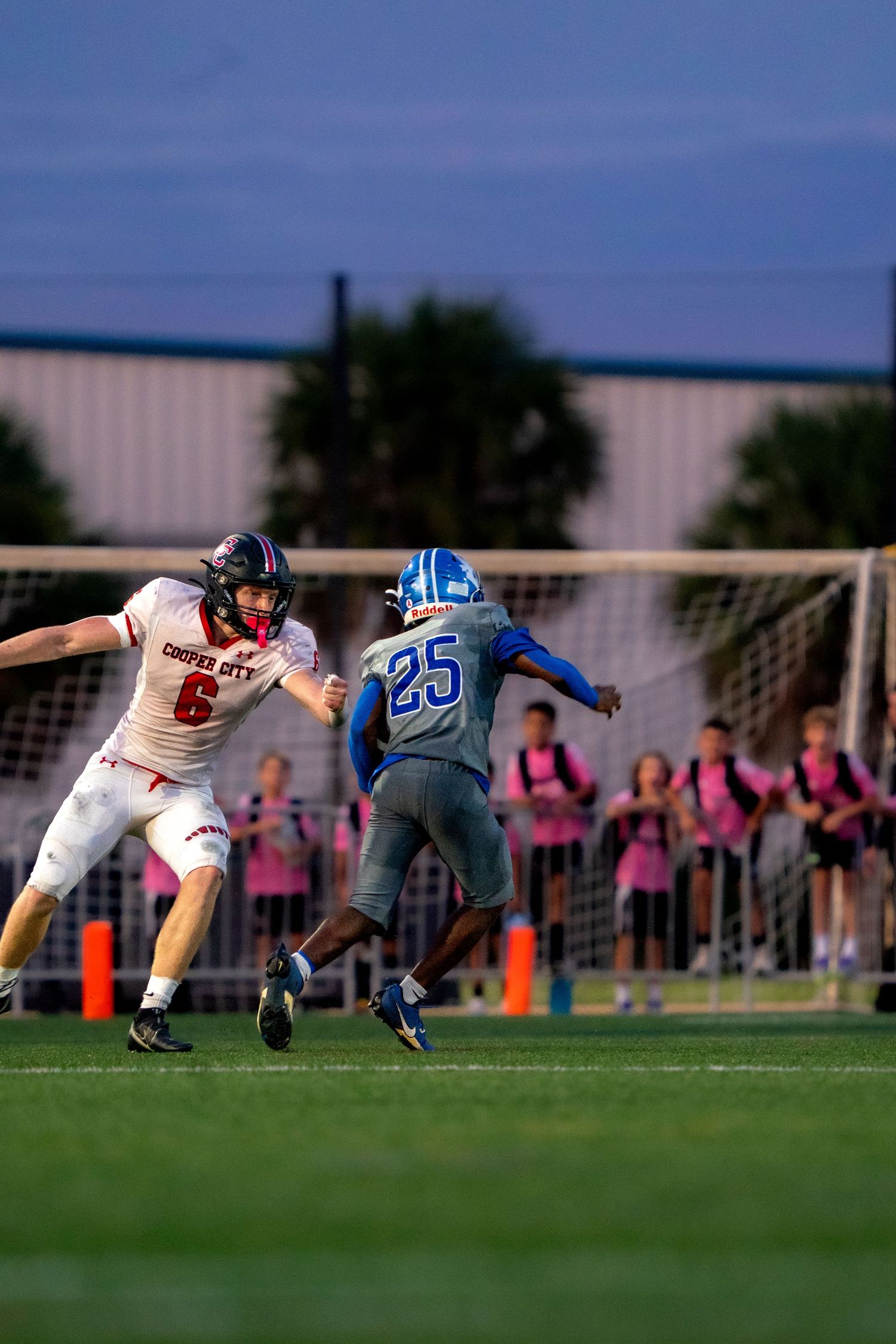 Players dive and stretch across the field during a competitive football play.