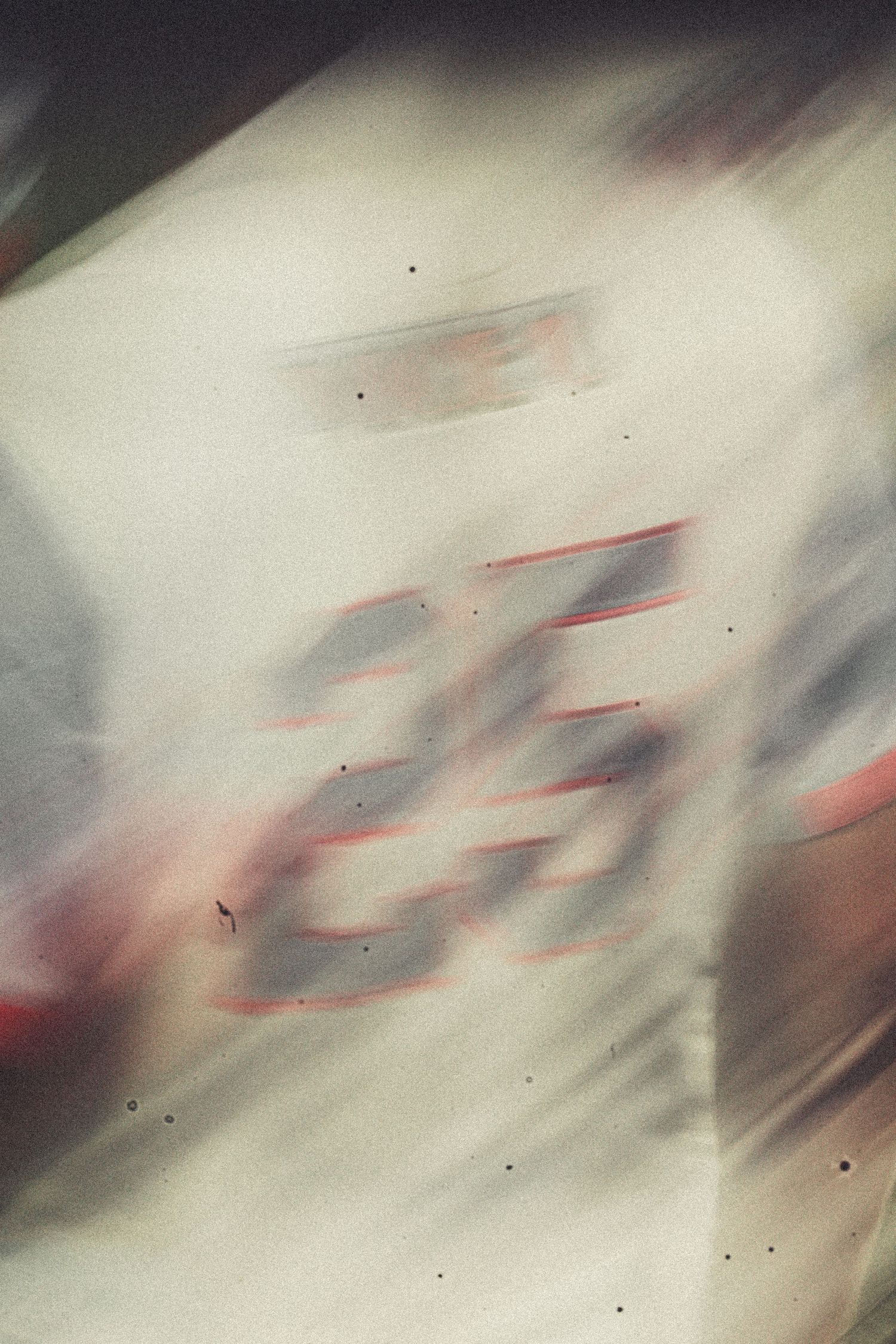 Blurred motion shot of a white racing car with number 25, captured at high speed on a racetrack.