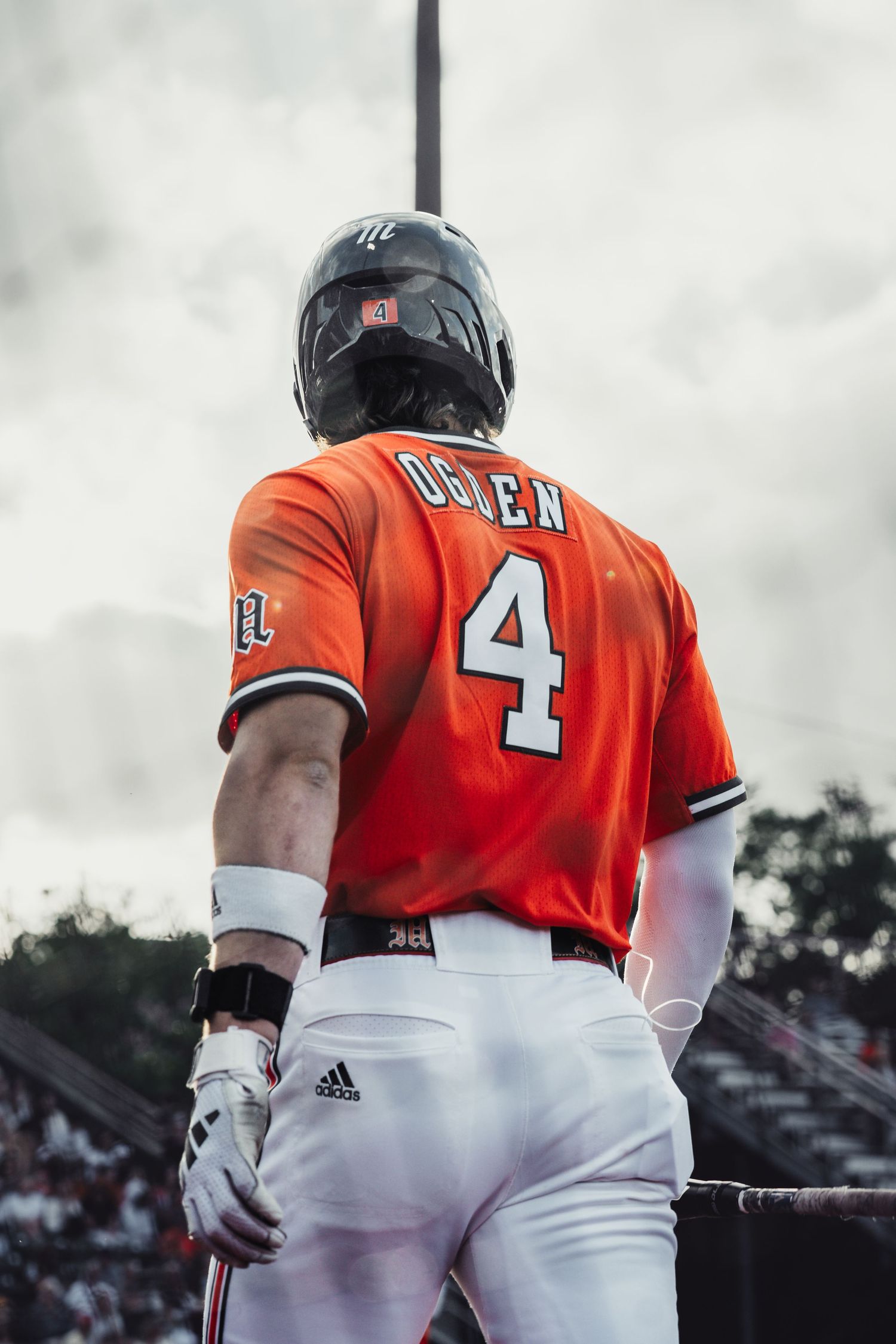 Baseball player Oglen wearing orange jersey number 4 and helmet stands ready at bat during a game.