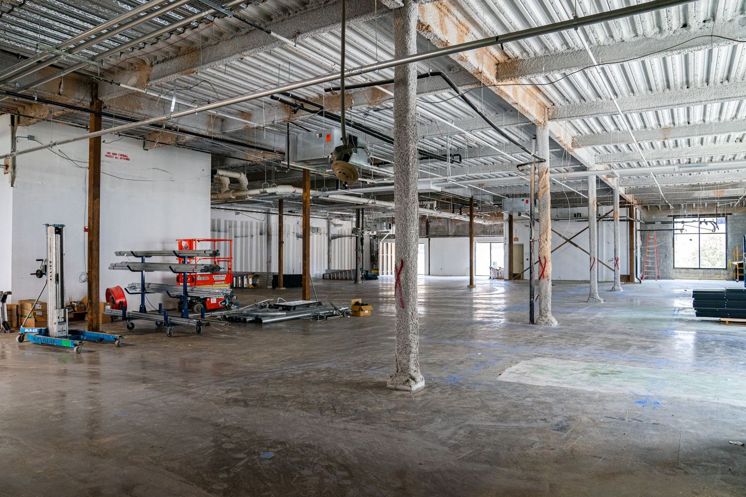 Expansive commercial space with natural lighting and exposed mechanical systems.