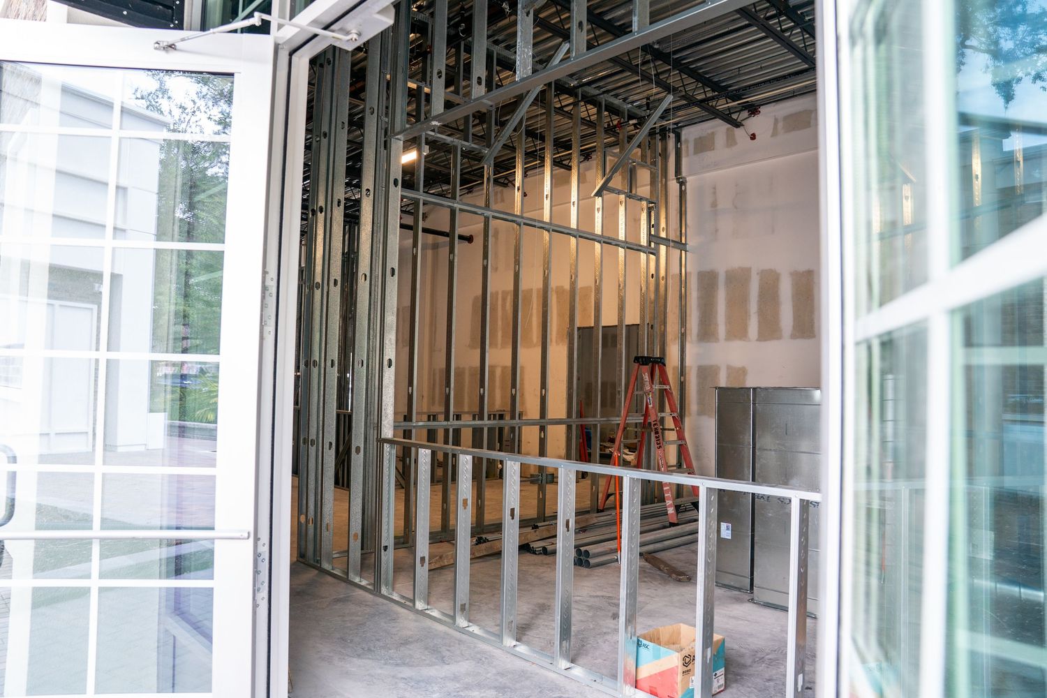 Large windows and metal framing visible in commercial construction project.