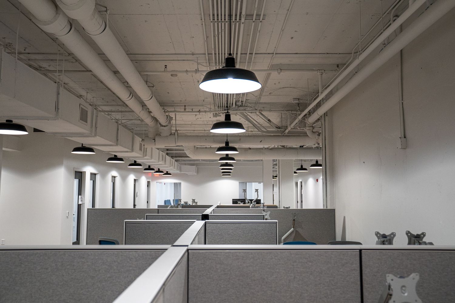 Large open commercial space with industrial lighting and exposed ceiling infrastructure.
