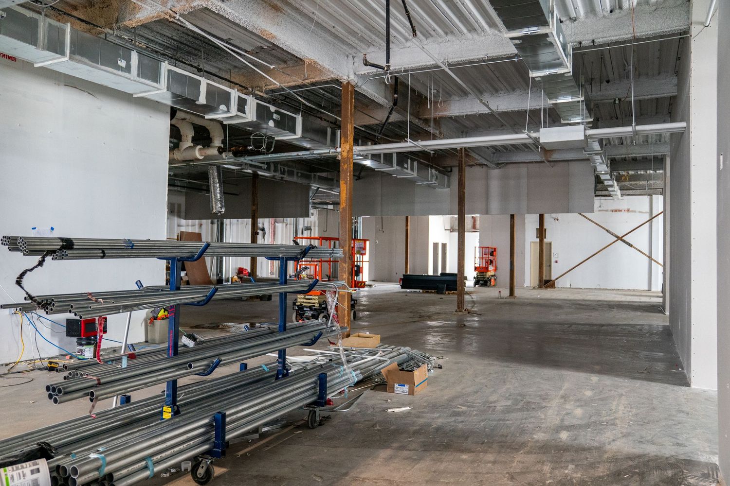 Industrial space with exposed ductwork and metal framing during construction phase.