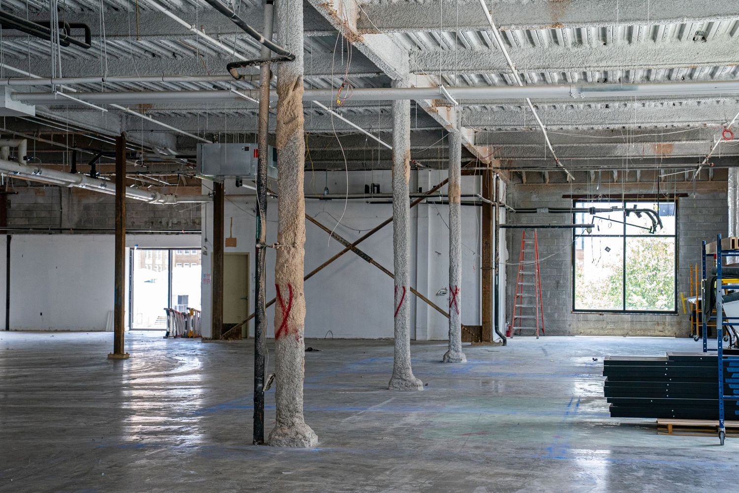 Panoramic view of unfinished commercial space with exposed ductwork and support beams.