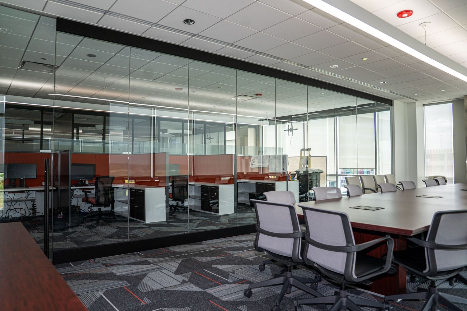 Executive conference space with glass partitions, contemporary seating, and natural lighting.