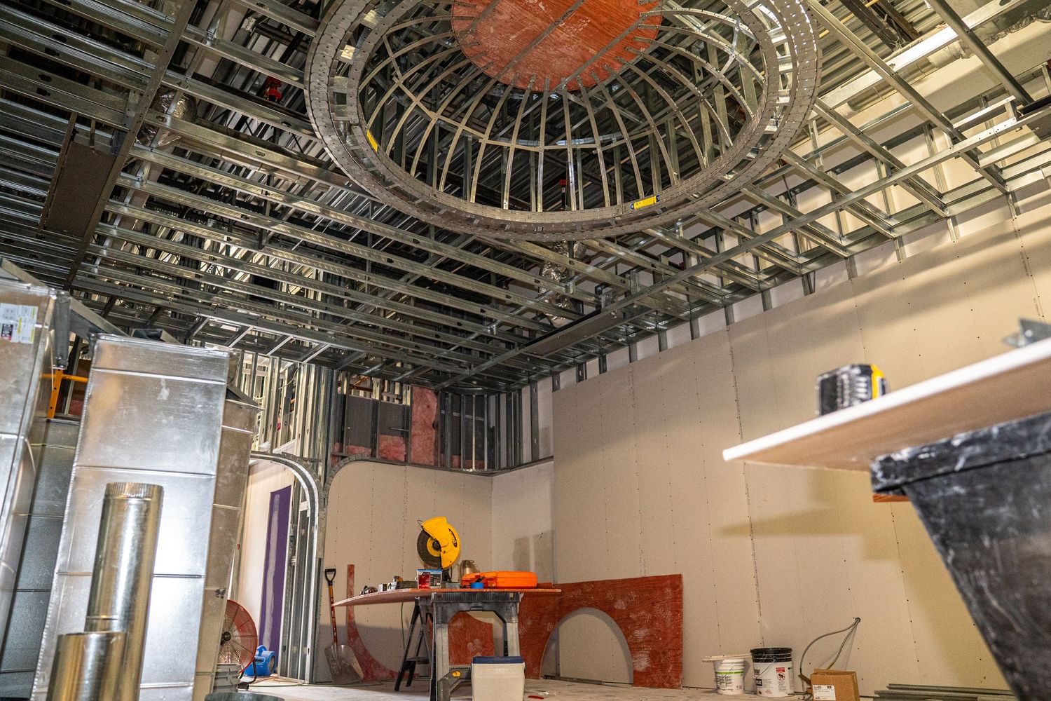 Architectural detail of circular dome ceiling with exposed infrastructure and lighting.