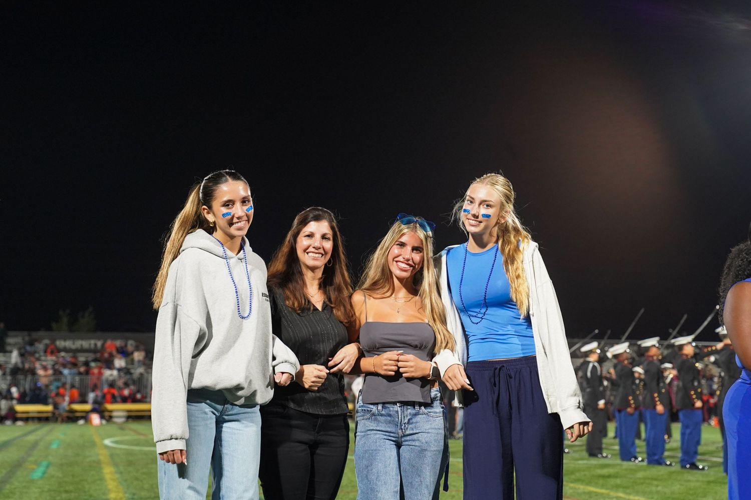 Students in casual attire gather together during a nighttime outdoor event.