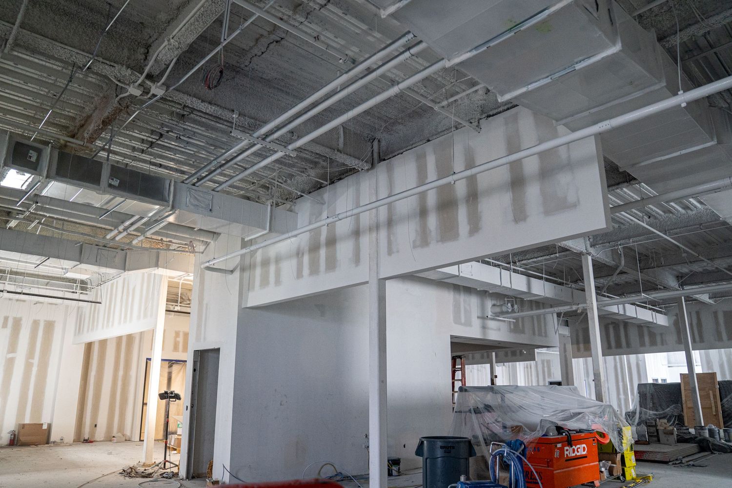 Commercial space renovation showing mechanical systems and construction equipment.