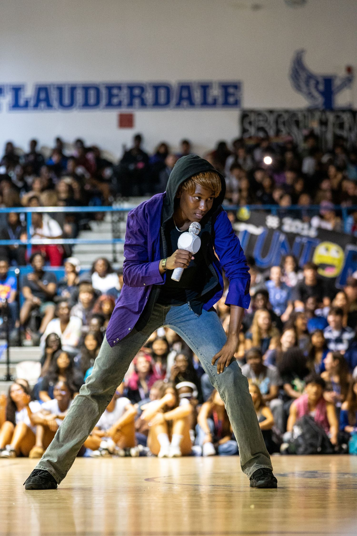 A student performs with a microphone at a Fort Lauderdale high school pep rally event.