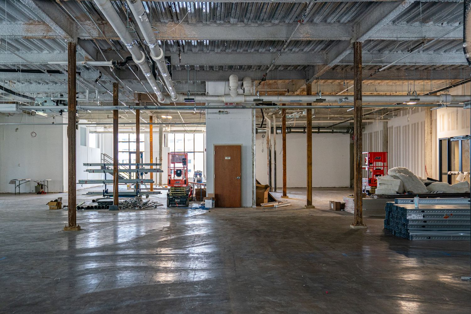 Industrial warehouse space with support beams and utility installations visible.