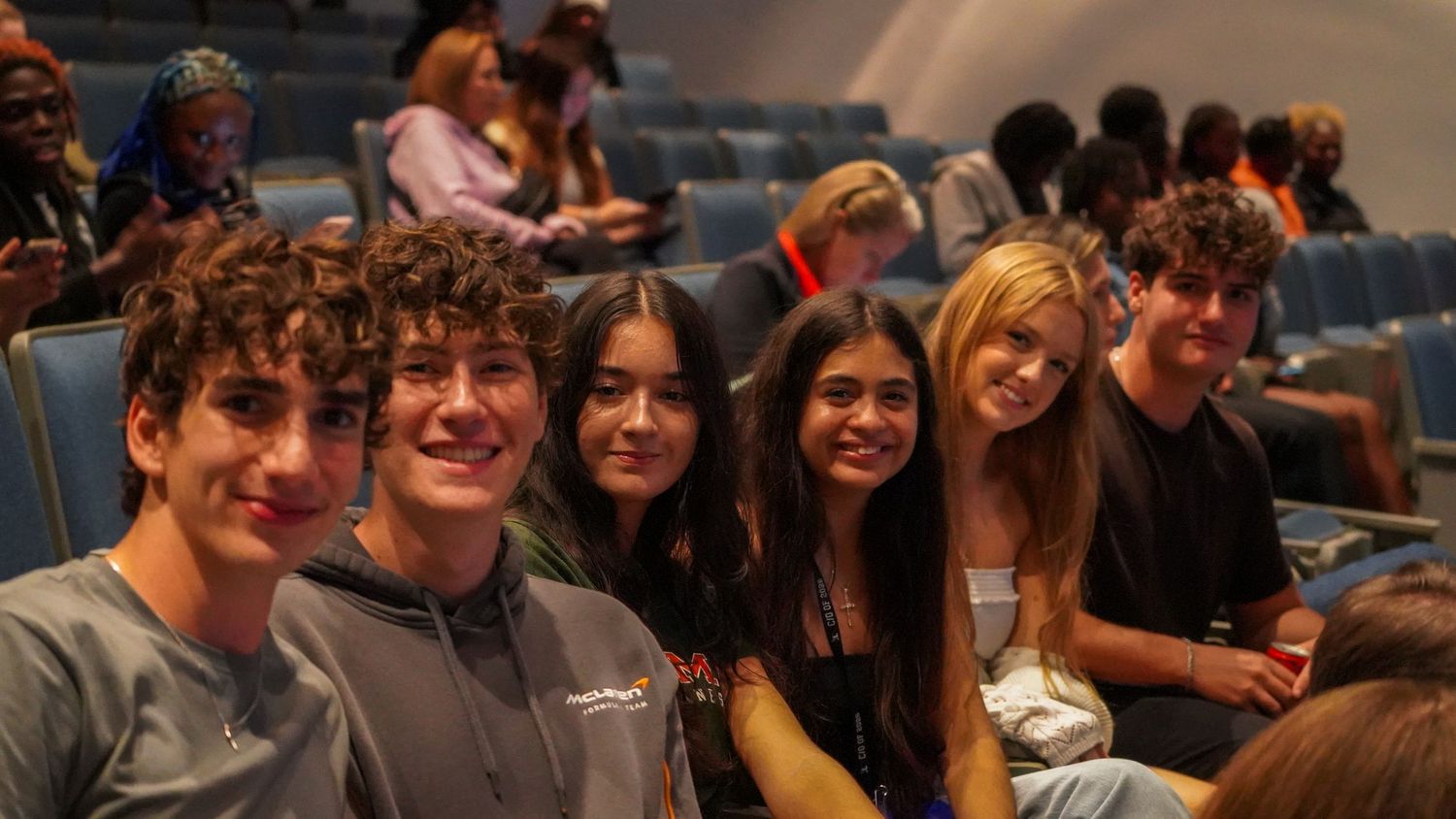 Audience members seated in rows watching an event in an auditorium.