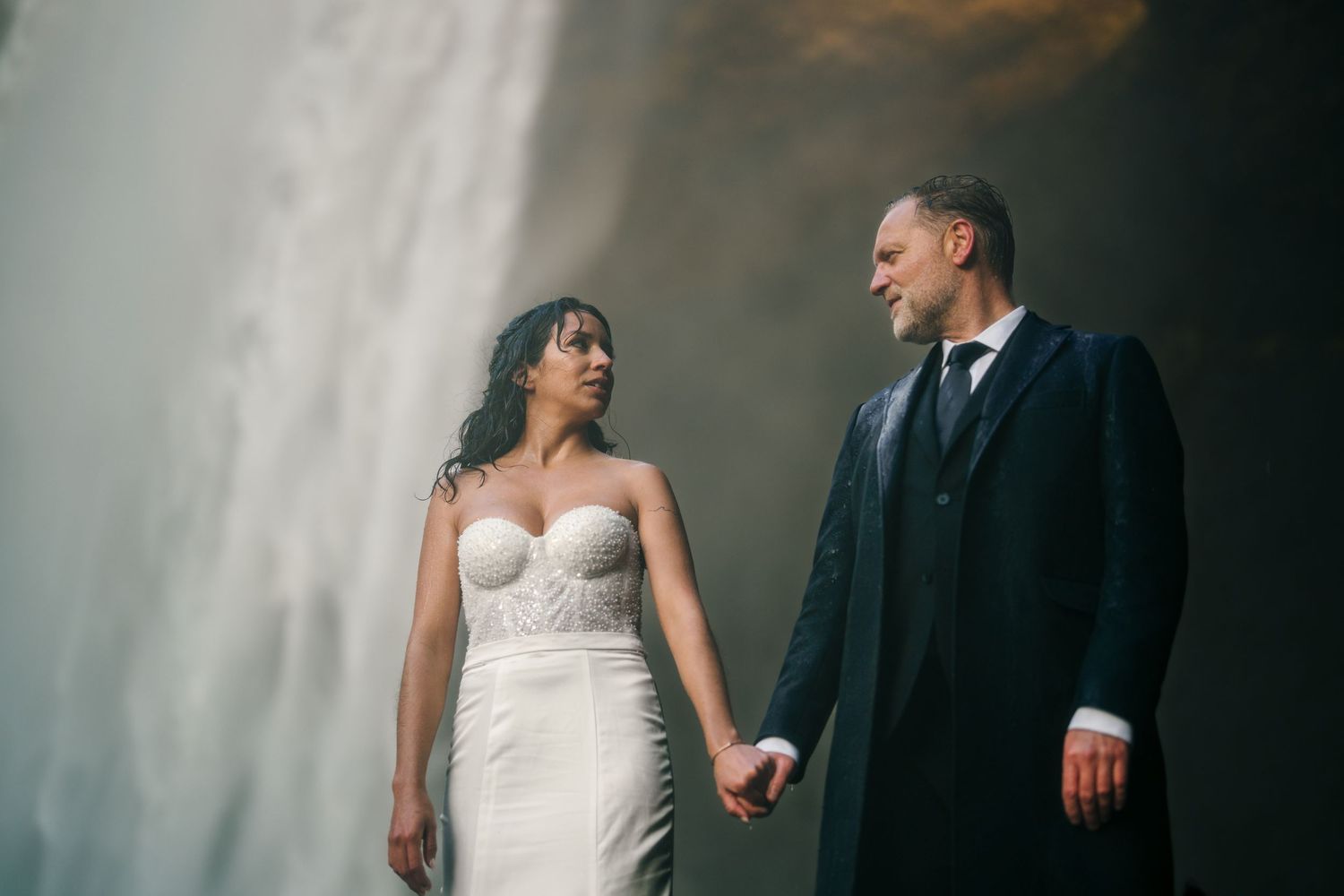 Iceland destination wedding. Romantic wedding couple poses together in front of a moody gray backdrop in an artistic photo series.