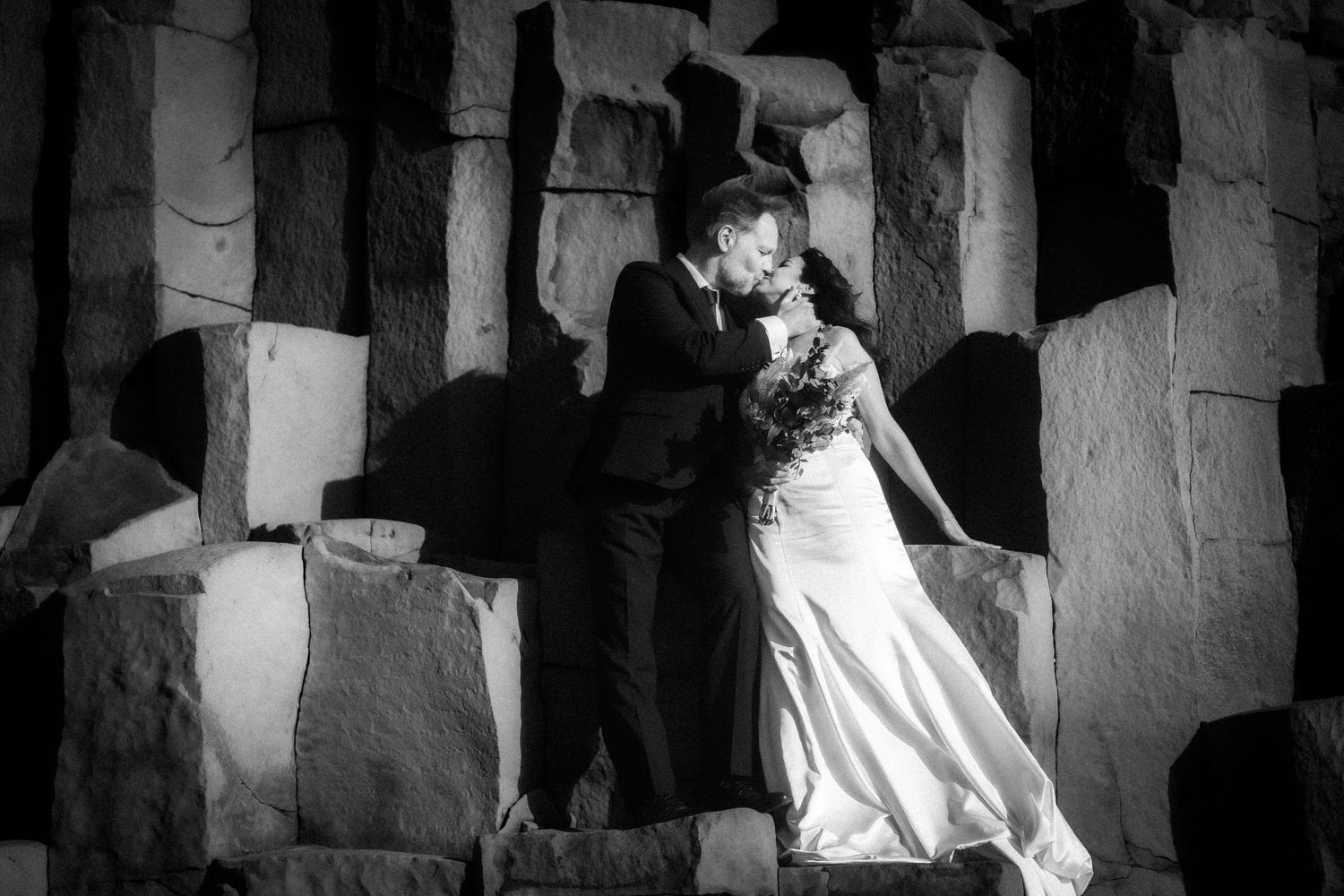 Iceland destination wedding. A dramatic black and white wedding photo series showing couples in elegant poses against architectural columns.