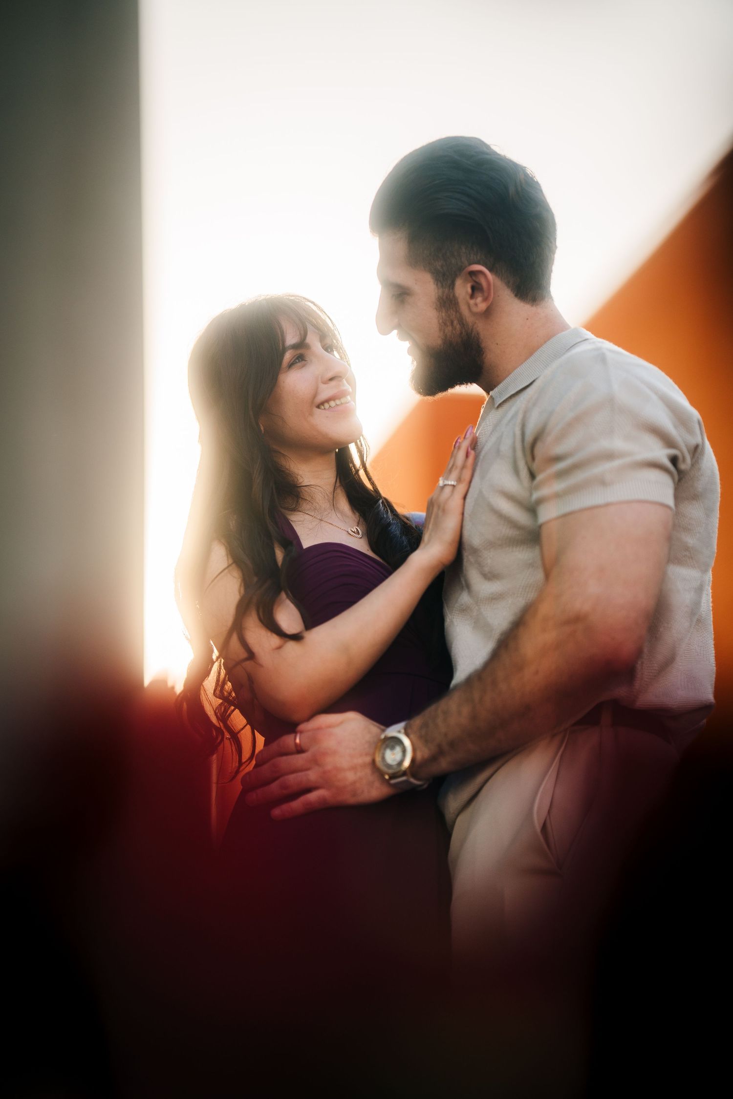 CN Tower Harborfront Proposal. A romantic couple embraces in warm sunset lighting, with her wearing purple and him in a grey shirt.