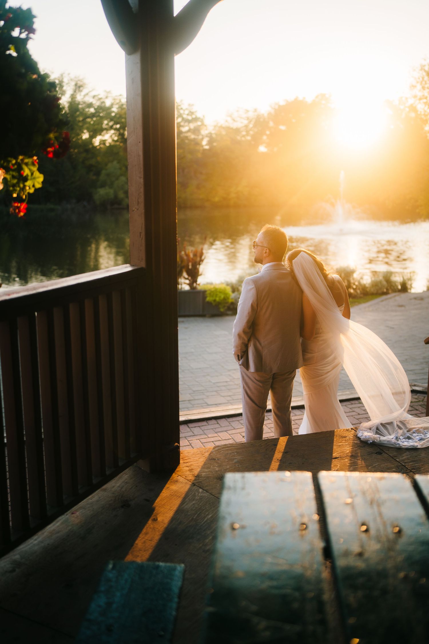 Mill Pond Park Wedding. Sunset photos showing sunlight streaming through wooden deck posts creating dramatic shadows and lens flare.