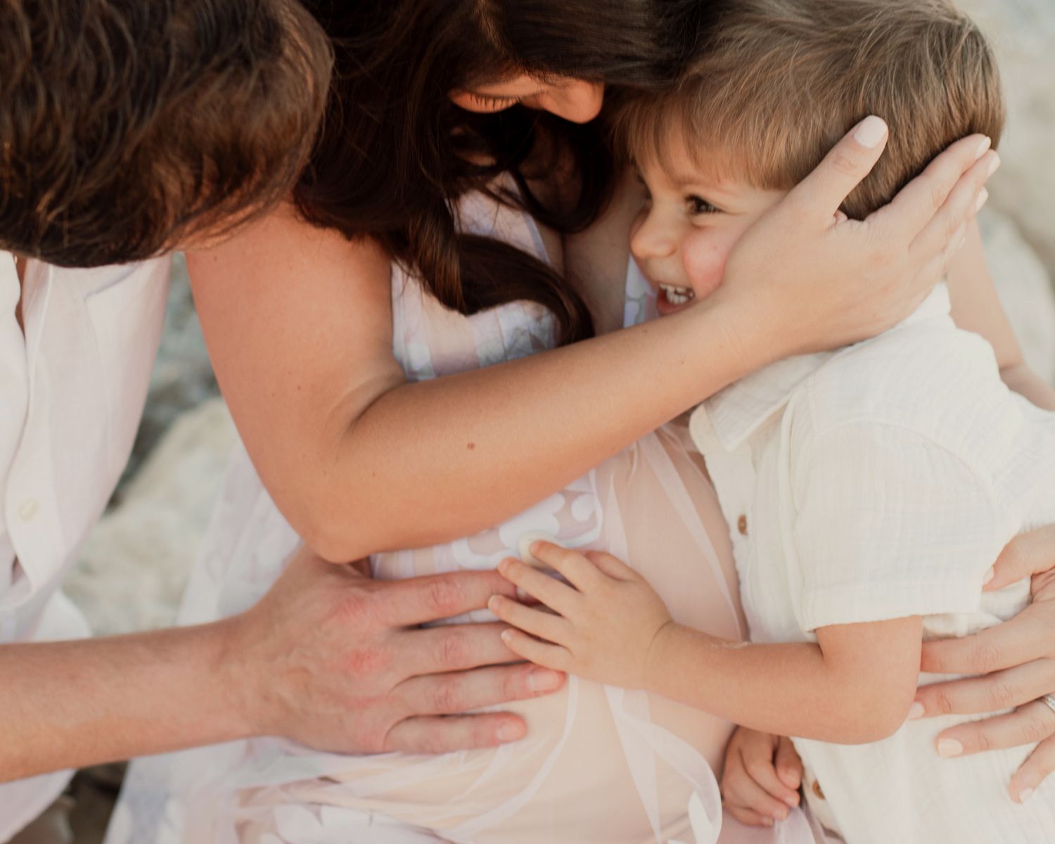 A loving mother hugs her joyful young son in a tender close-up family portrait.