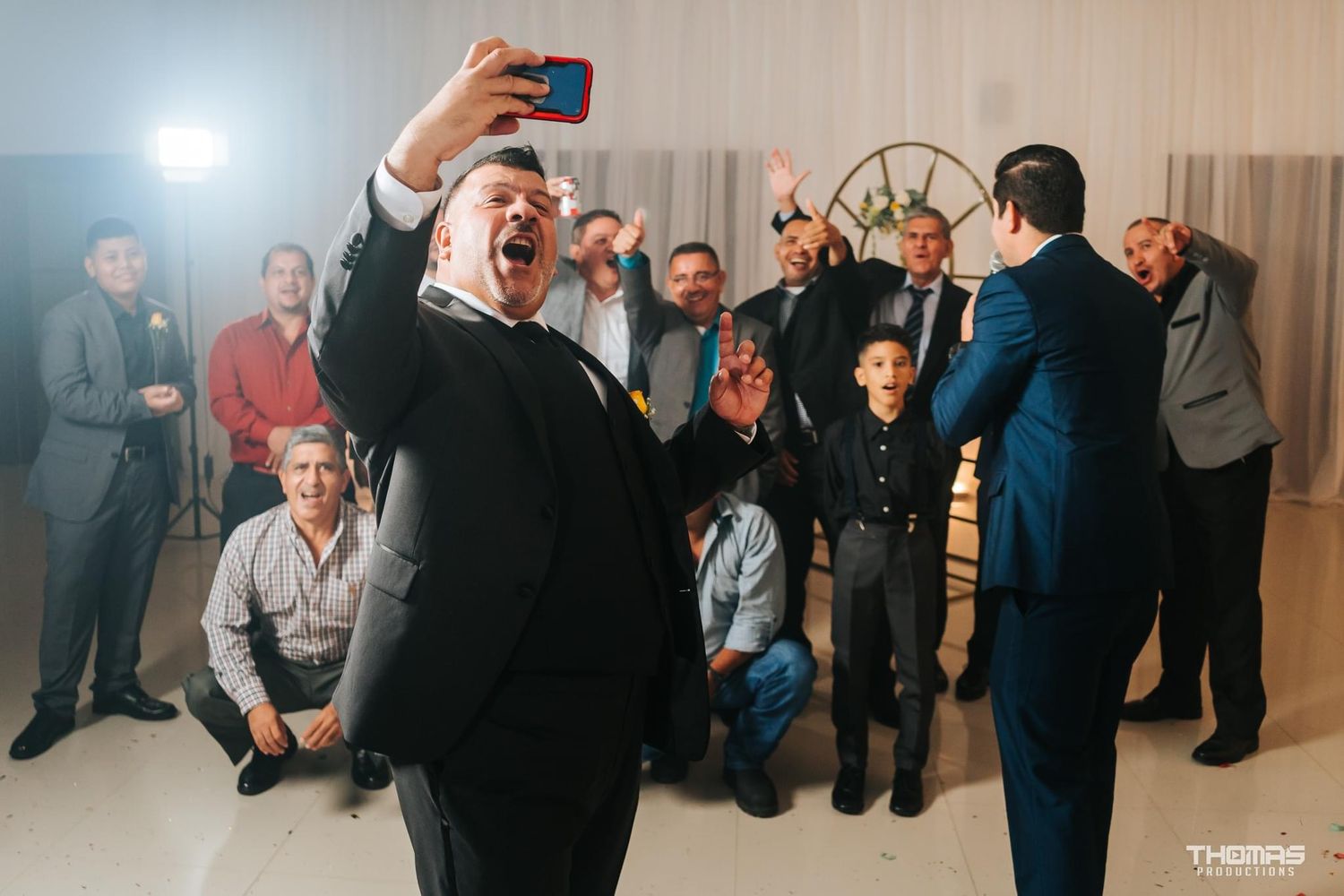 Energetic party scene with people taking selfies in an indoor venue.