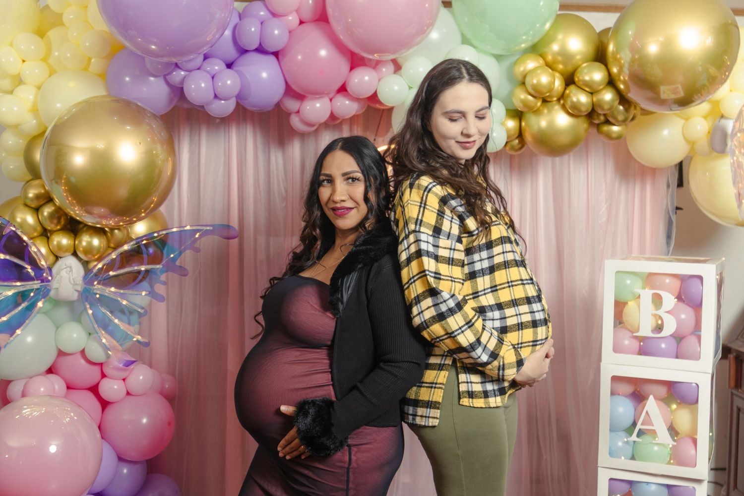 Baby shower celebration with colorful balloon arch and festive decorations.