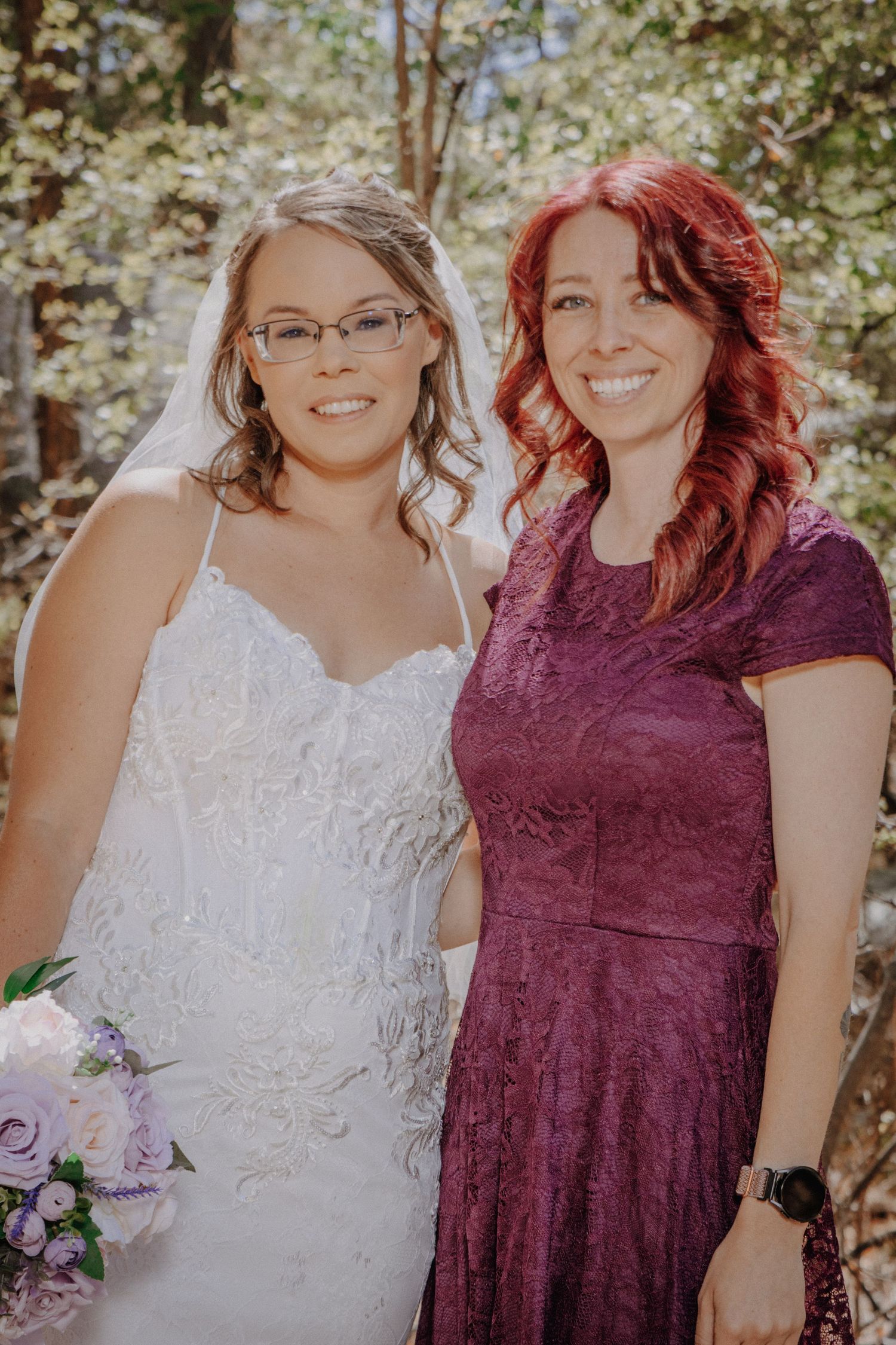 Outdoor wedding portrait in natural forest setting with soft lighting.