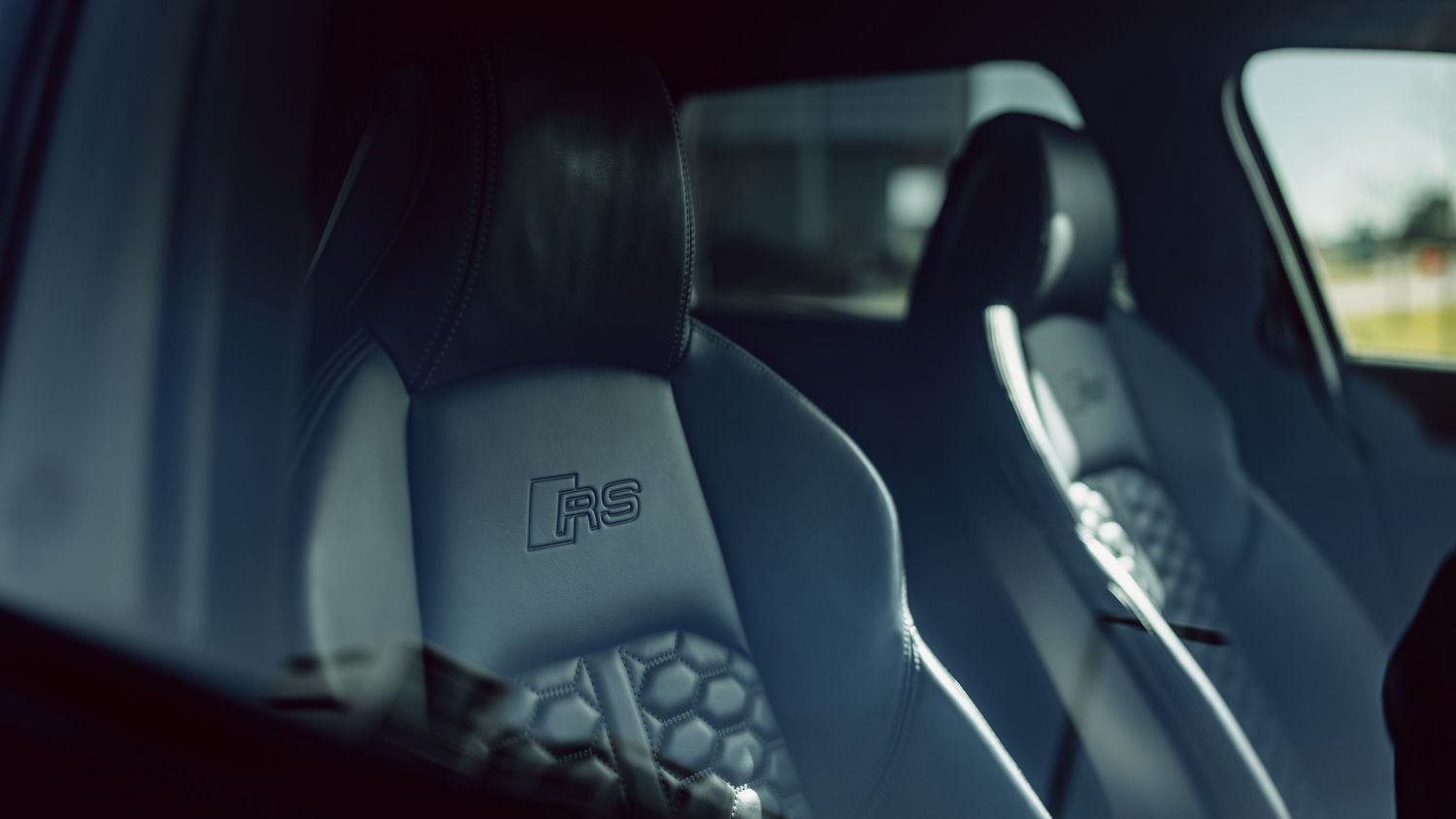 Close-up of Audi RS branded sport seats with premium gray leather interior detailing.