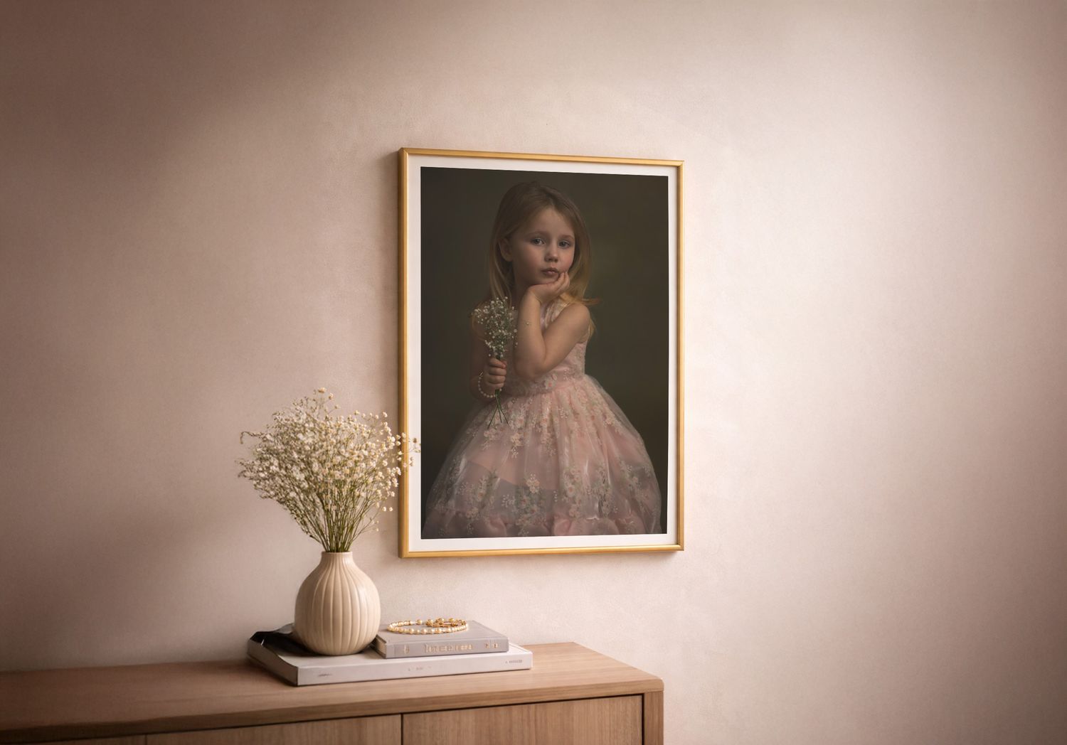 Ingelijst kinderportret van een meisje in een roze bloemenjurk op een houten dressoir met droogbloemen. 💛