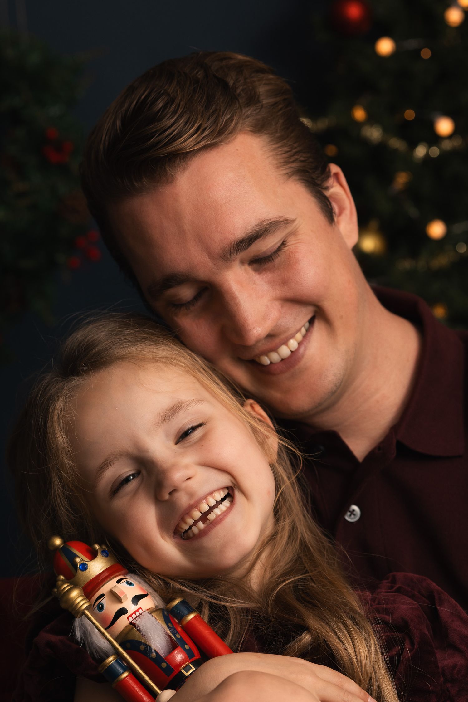 Vader en dochter dicht bij elkaar tijdens een ontspannen kerstfotoshoot bij Mini Mellow.