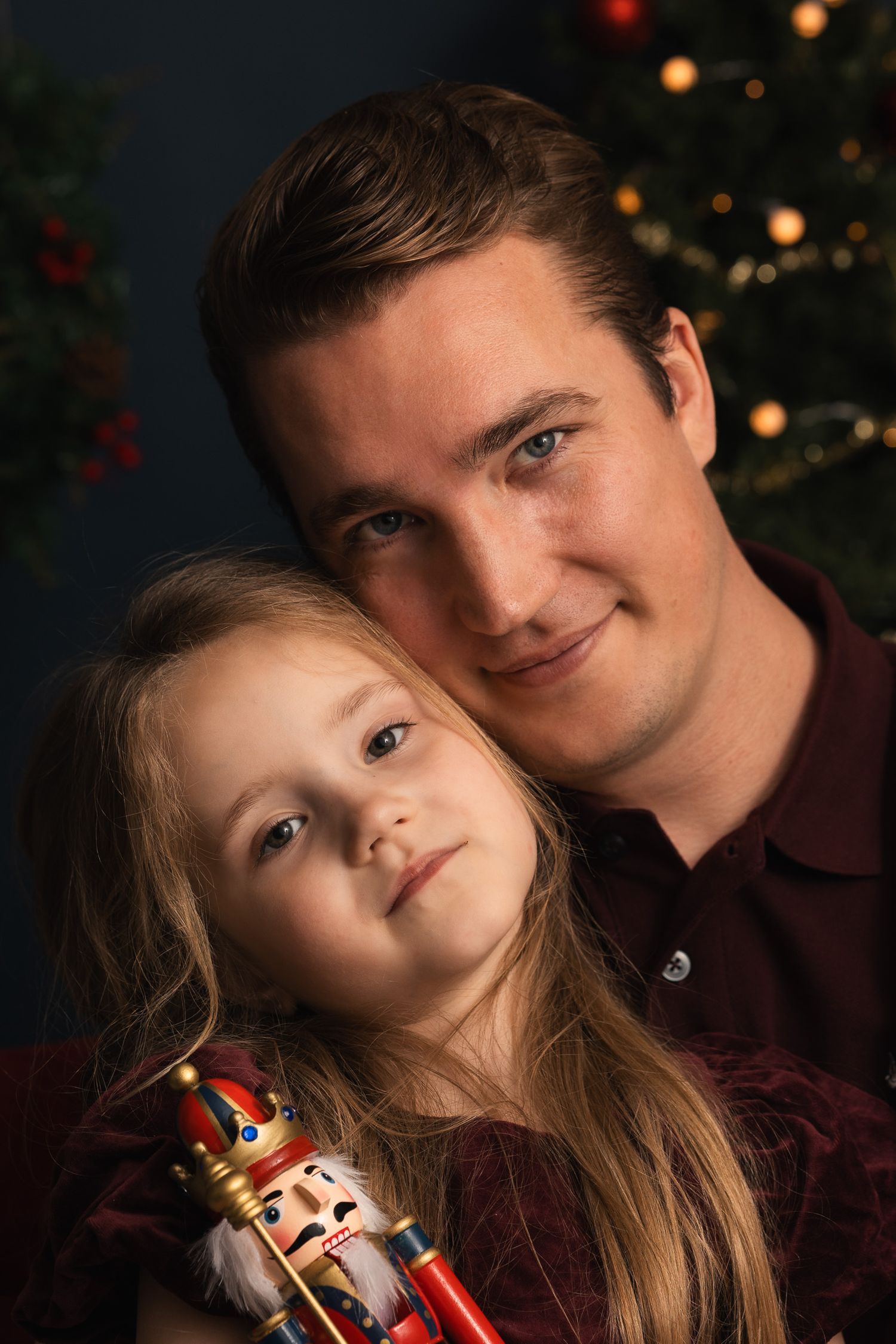 Vader en dochter samen tijdens een rustige kerstfotoshoot in de studio van Mini Mellow.