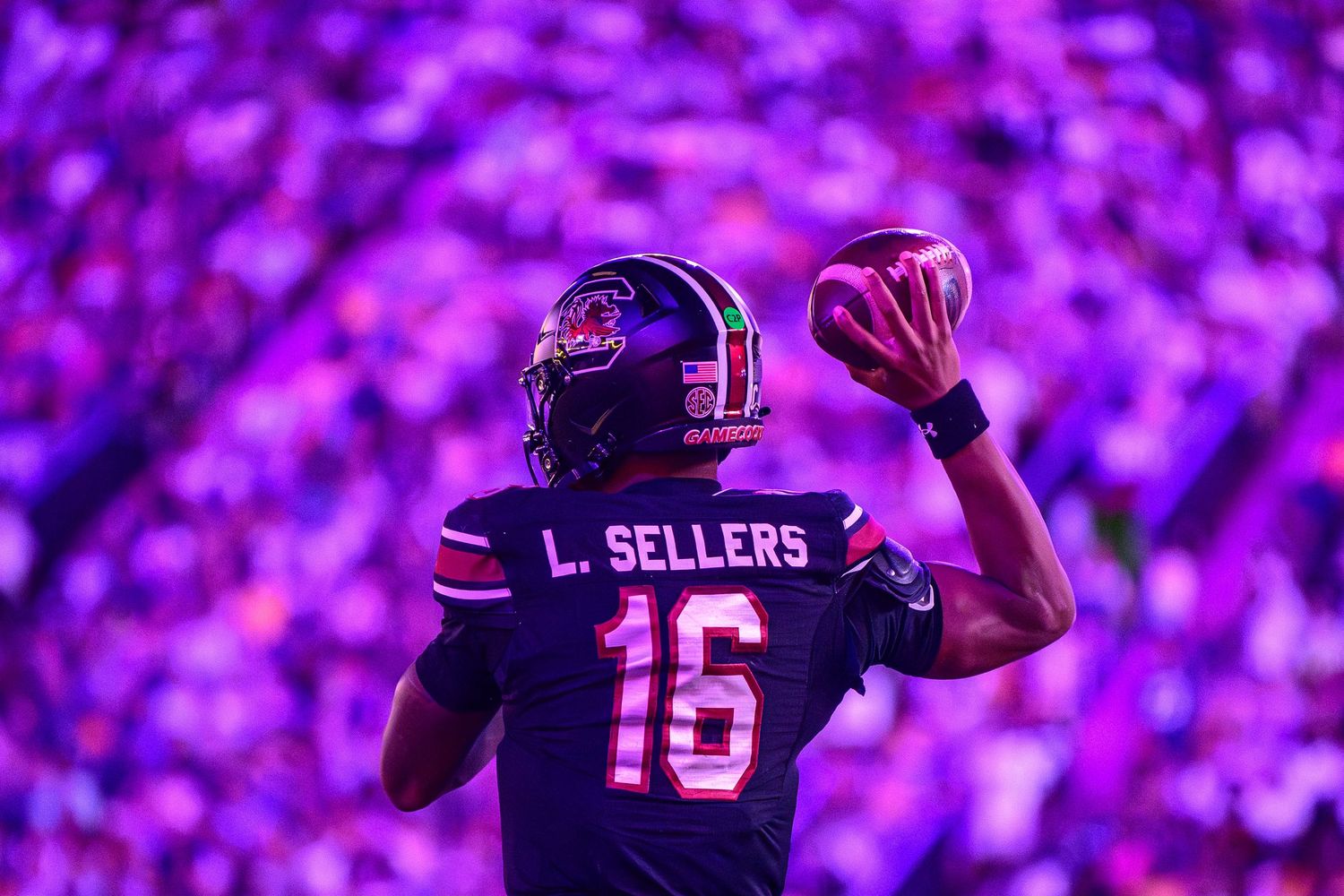 South Carolina quarterback LaNorris Sellers (16) looks downfield to pass against a vibrant purple-lit stadium crowd at LSU's Tiger Stadium.