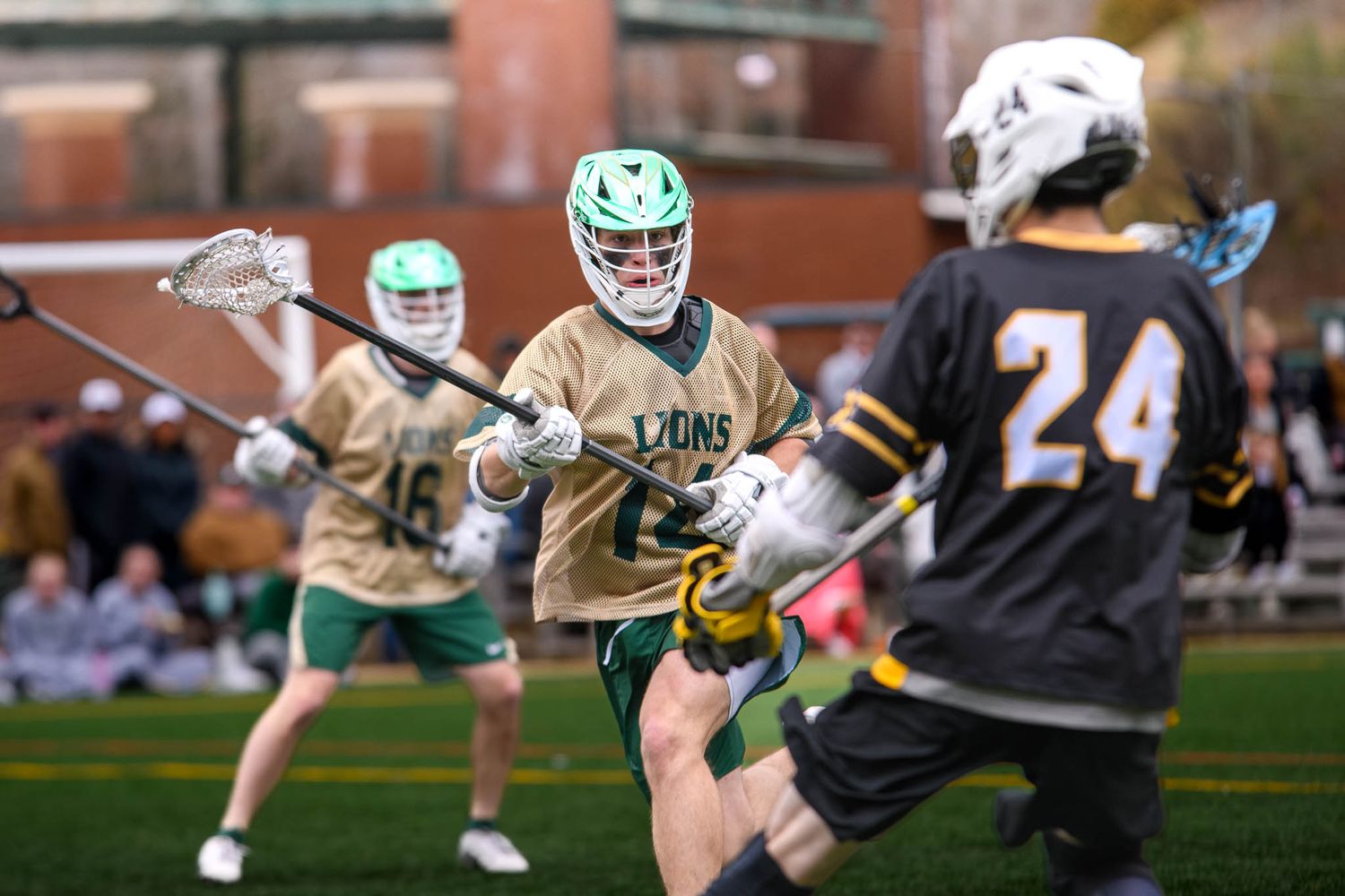 A Piedmont University lacrosse player in a green and white uniform maneuvers past a defender during a collegiate game.