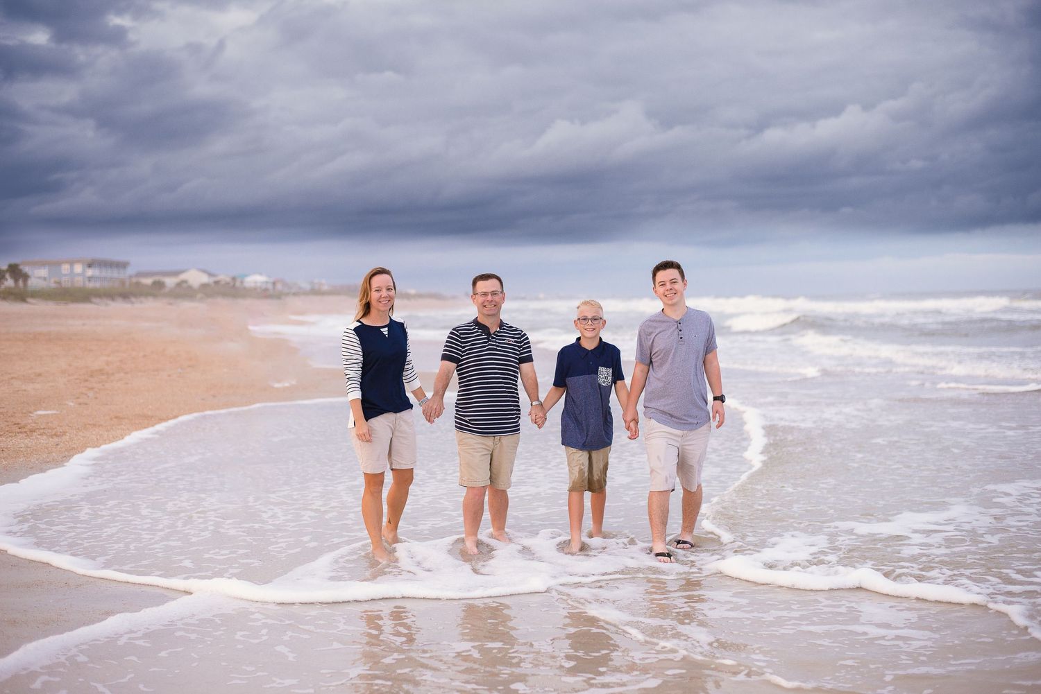 Family of four standing in the surf — natural light beach portrait session by Alexandra Hall, Vilano Beach St Augustine FL