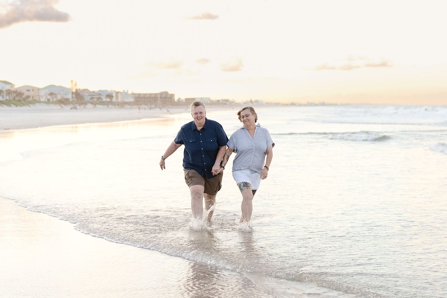 Couple walking hand in hand through the surf at sunset — Vilano Beach family photography by Alexandra Hall, St. Augustine F