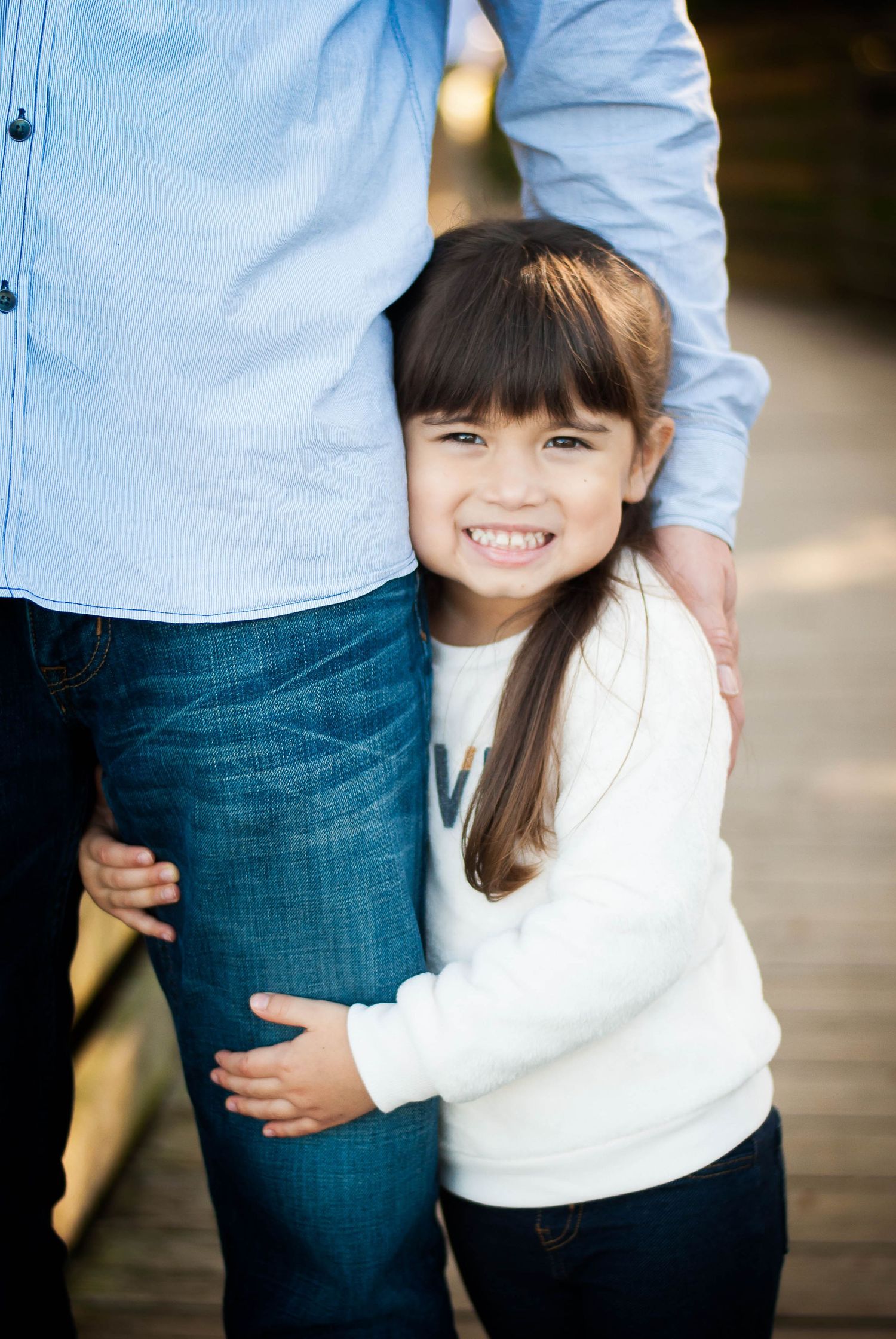 Parent holding young child outdoors — candid natural light family portrait by Alexandra Hall, Northeast Florida