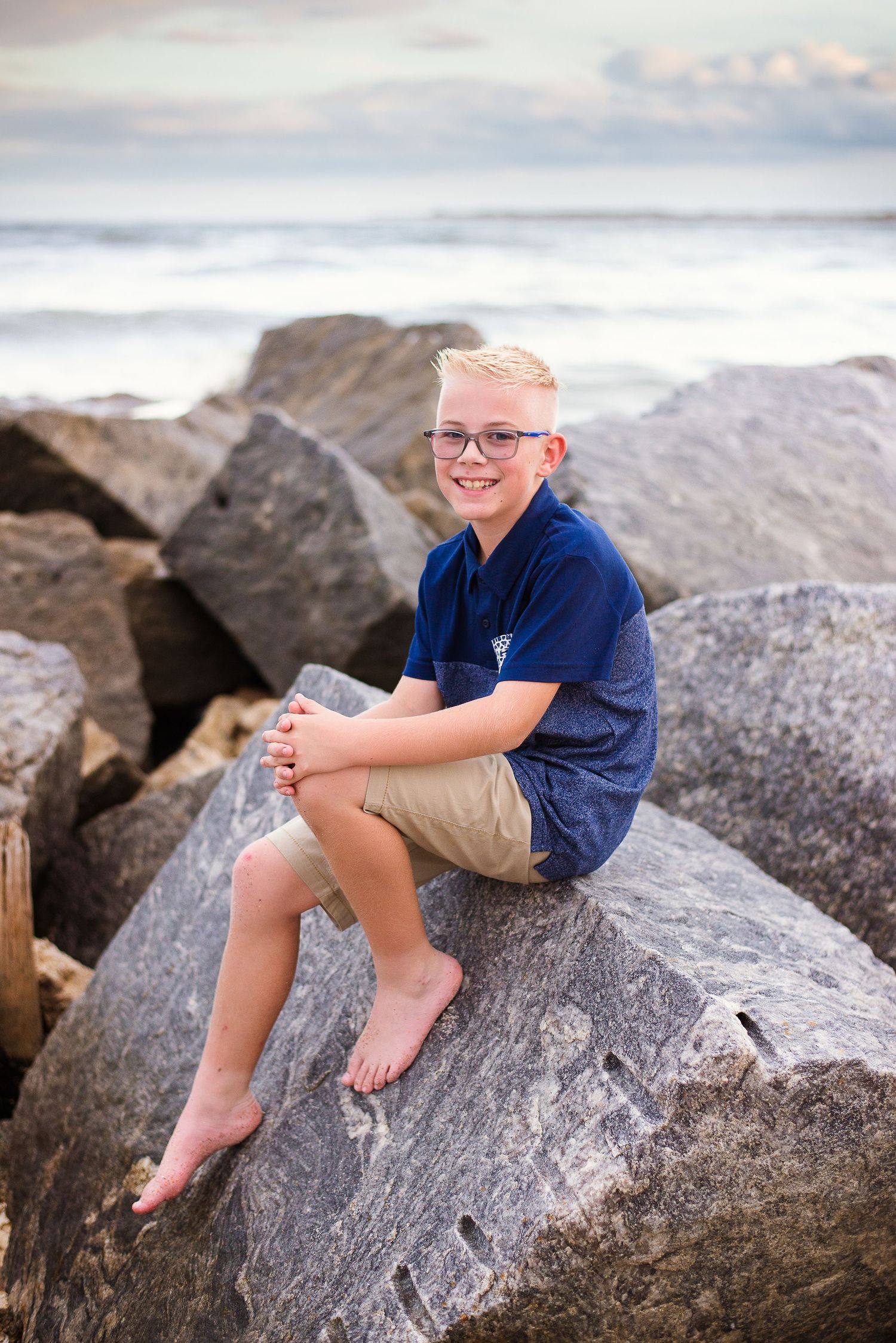 Candid family portrait on coastal rocks — natural light beach photography by Alexandra Hall, St. Augustine FL