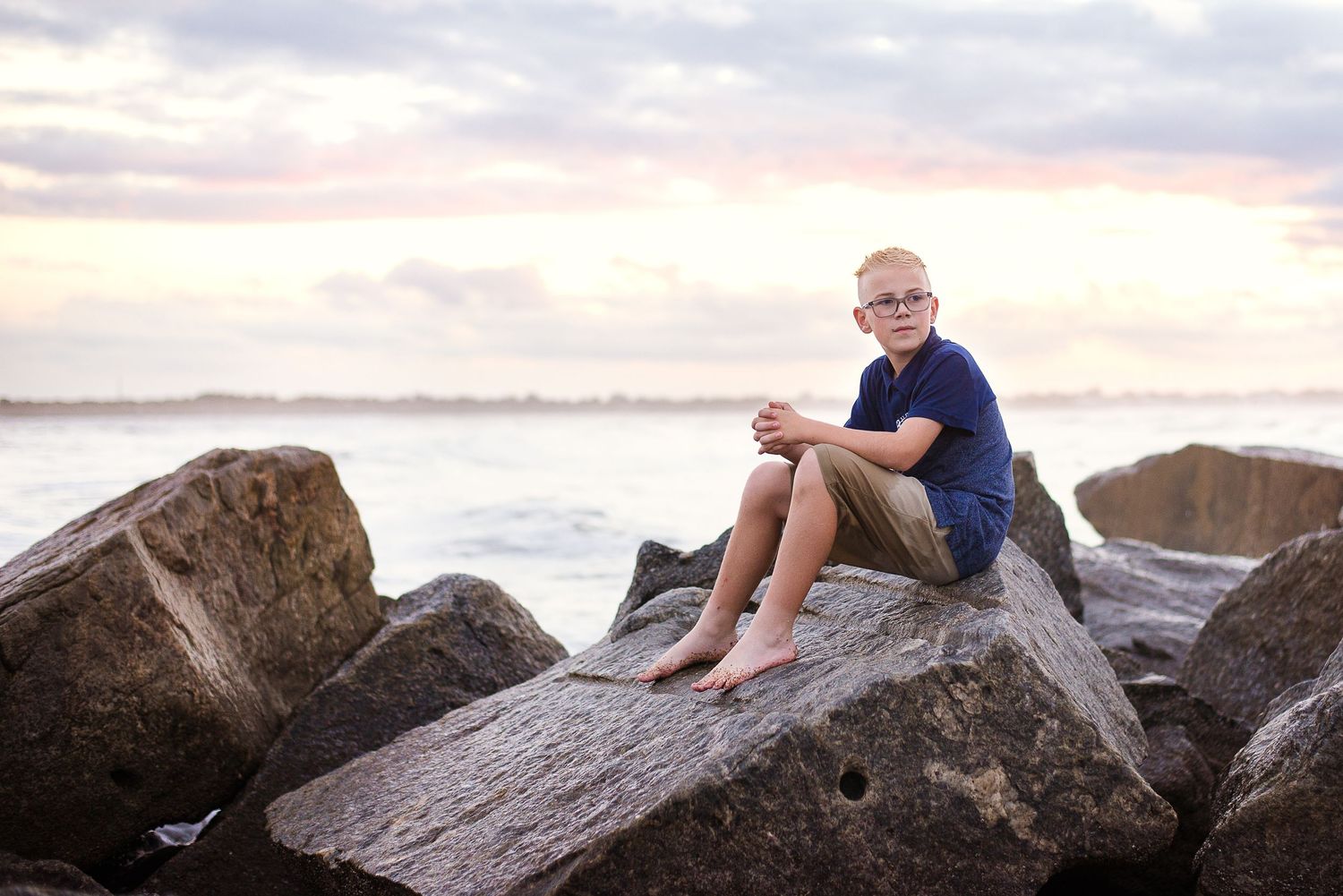 Young child portrait on coastal rocks at sunset — natural light family photography by Alexandra Hall, Vilano Beach St Augustine FL