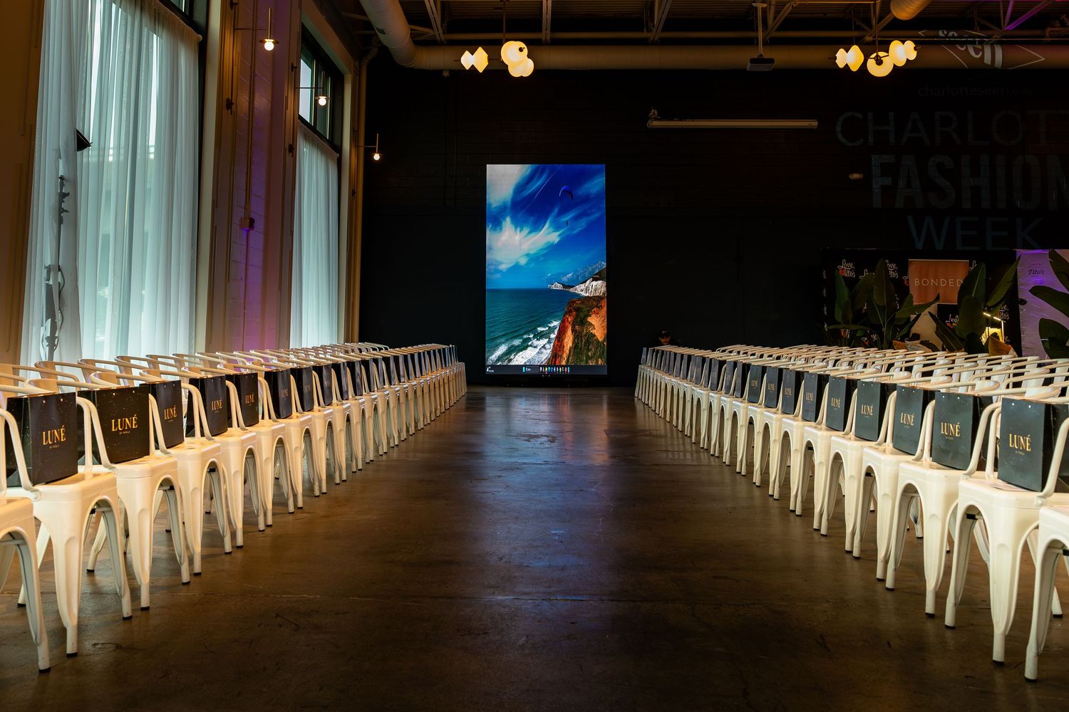 Rows of white chairs beside the runway before the Charlotte Fashion Week show.