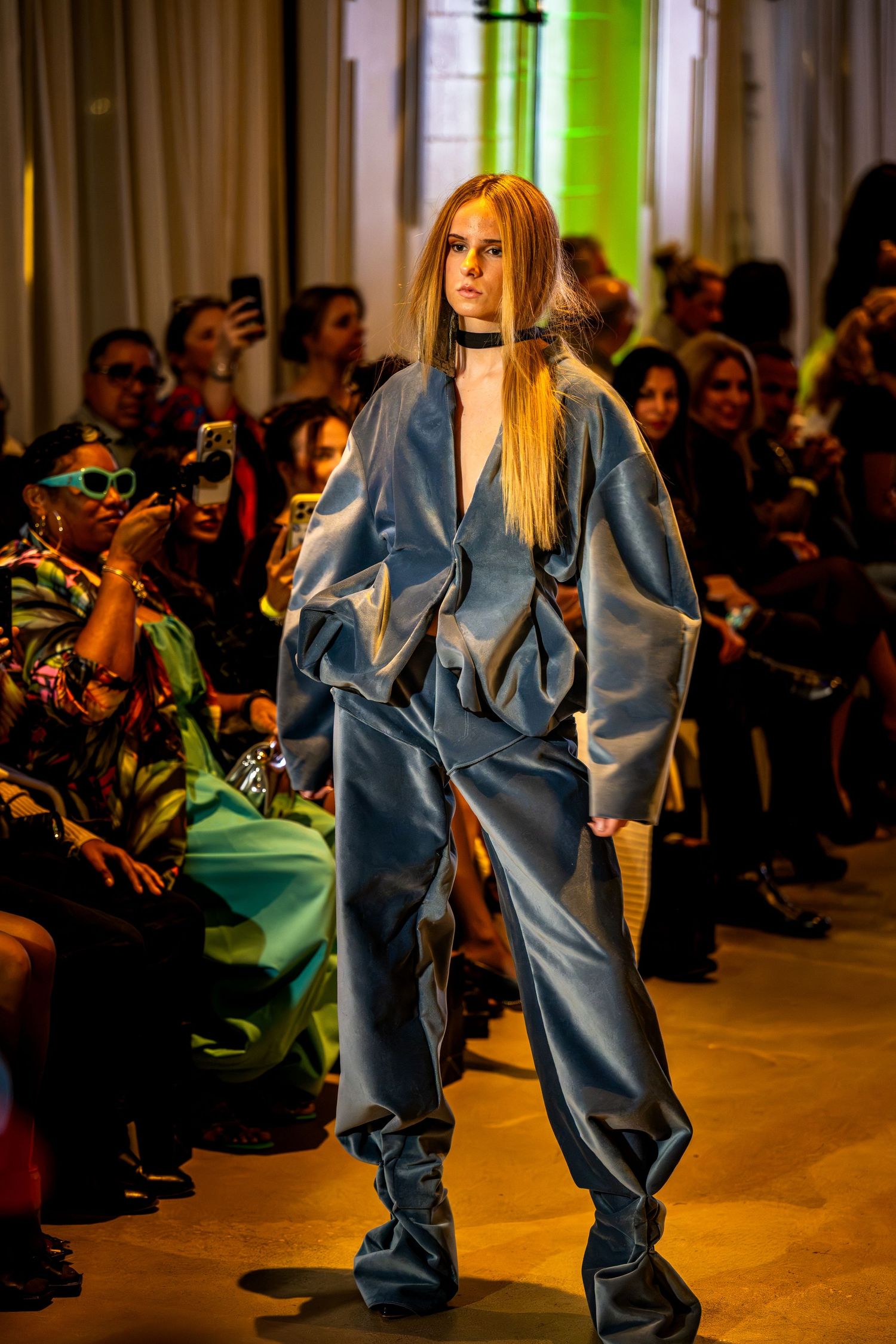 Model wearing a sculptural blue suit on the runway at Charlotte Fashion Week.