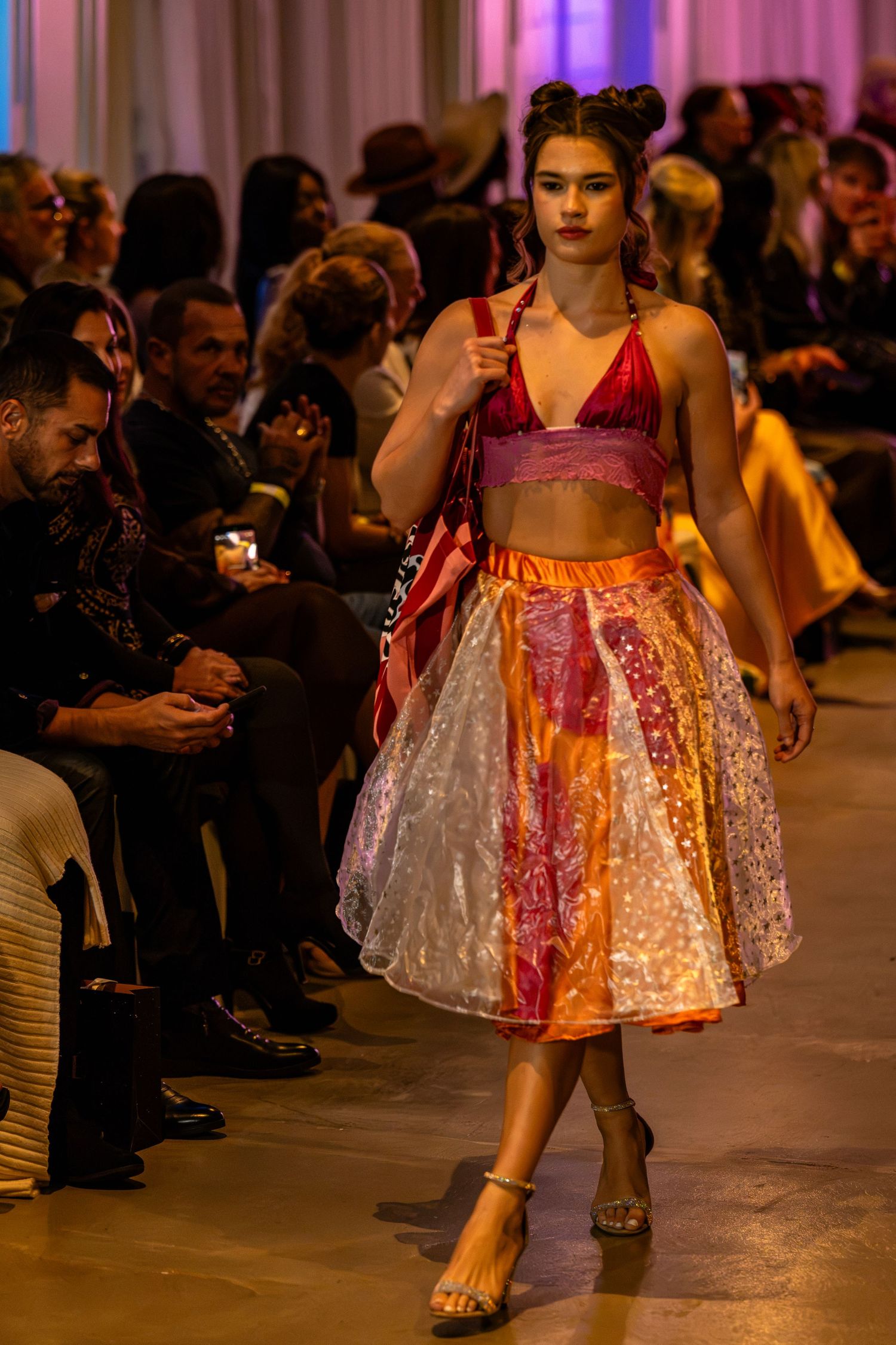 Model wearing a red crop top and colorful patchwork midi skirt on the Charlotte Fashion Week runway.