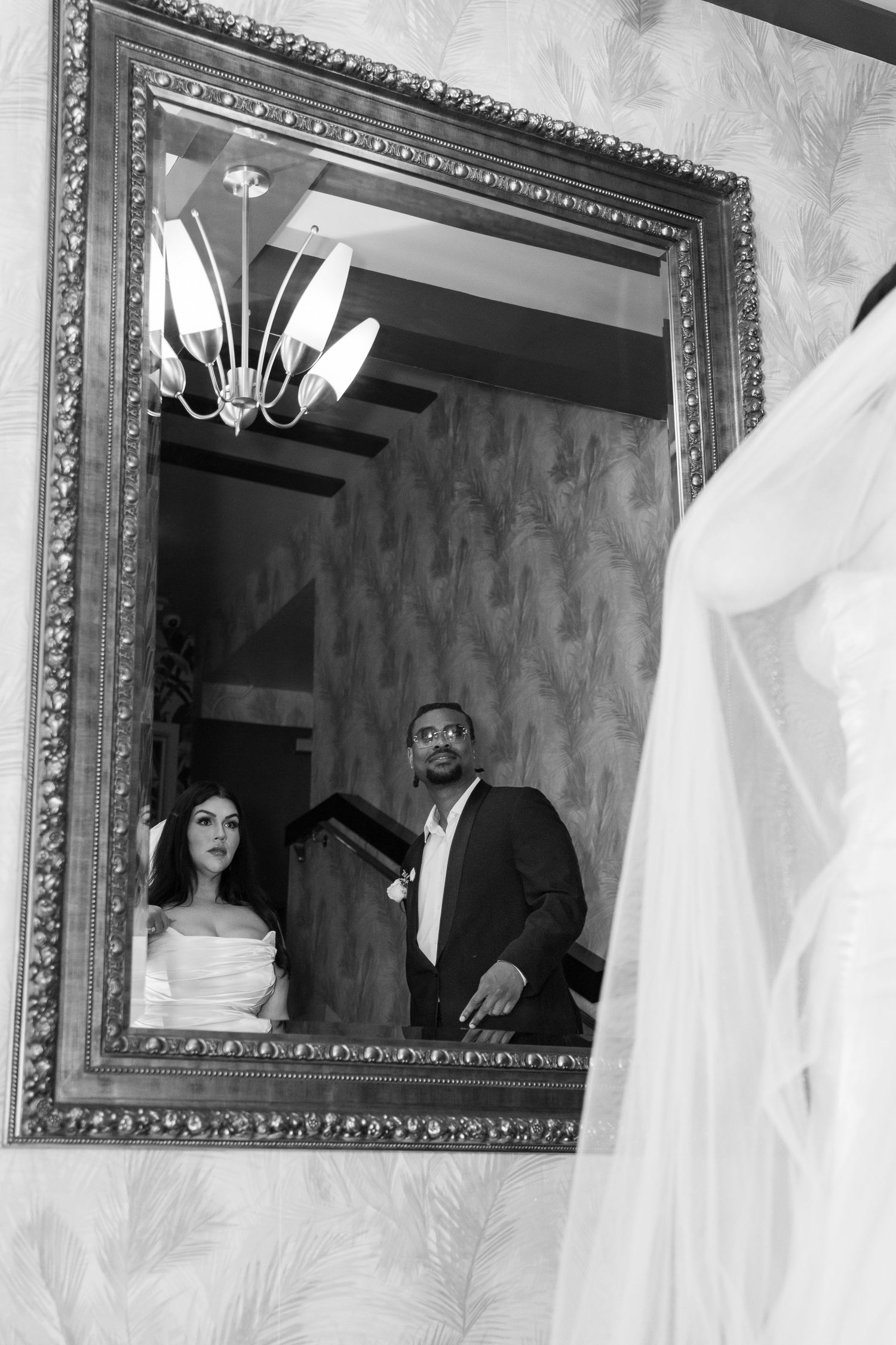 Black and white photo of bride and groom reflected in ornate gold mirror at wedding. Las Vegas elopement photographer
