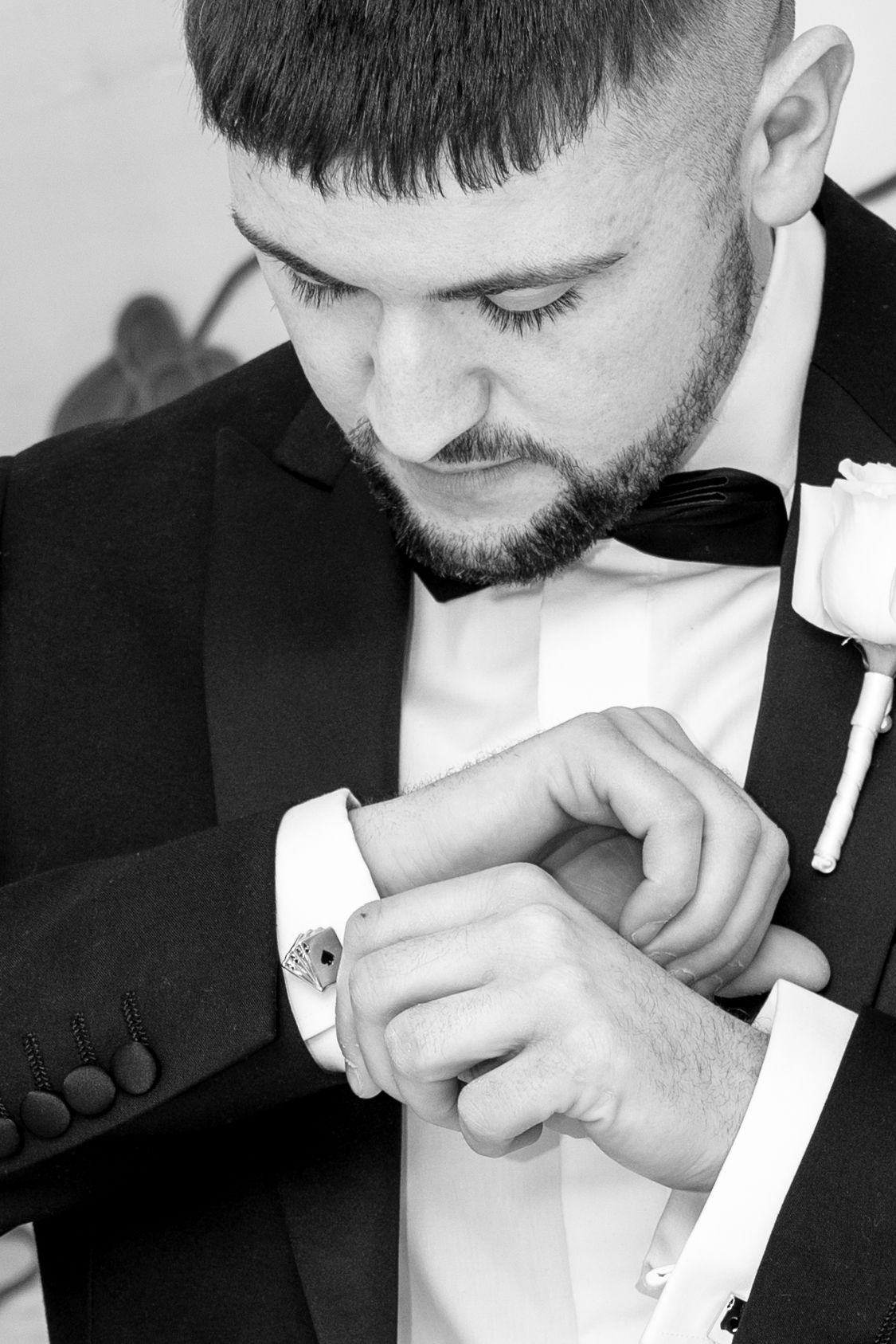Groom in tuxedo adjusting cufflinks before wedding ceremony in black and white. Las Vegas elopement photographer