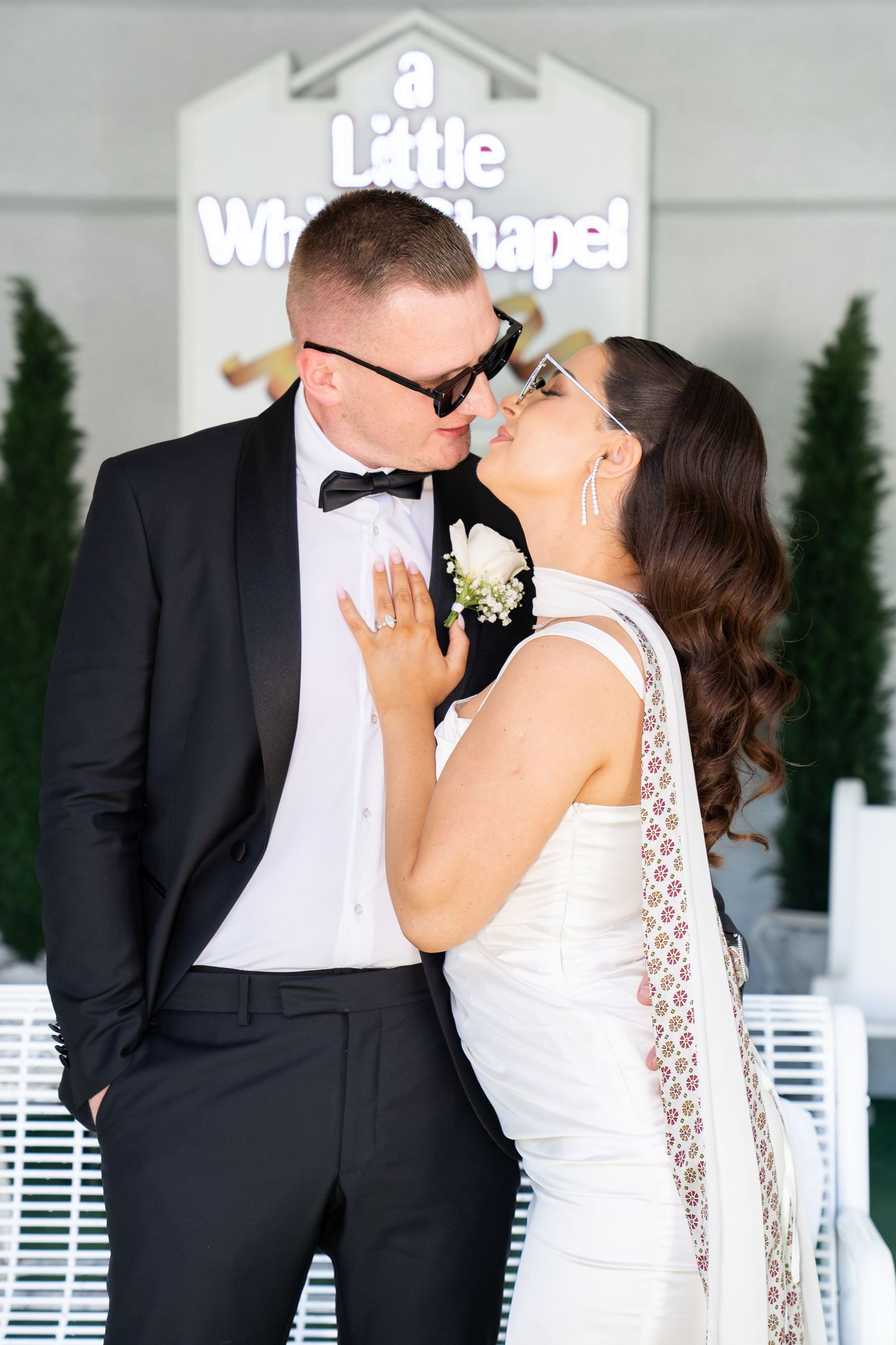 Bride and groom kissing outside Little White Chapel in Las Vegas wearing sunglasses. Las Vegas elopement photographer