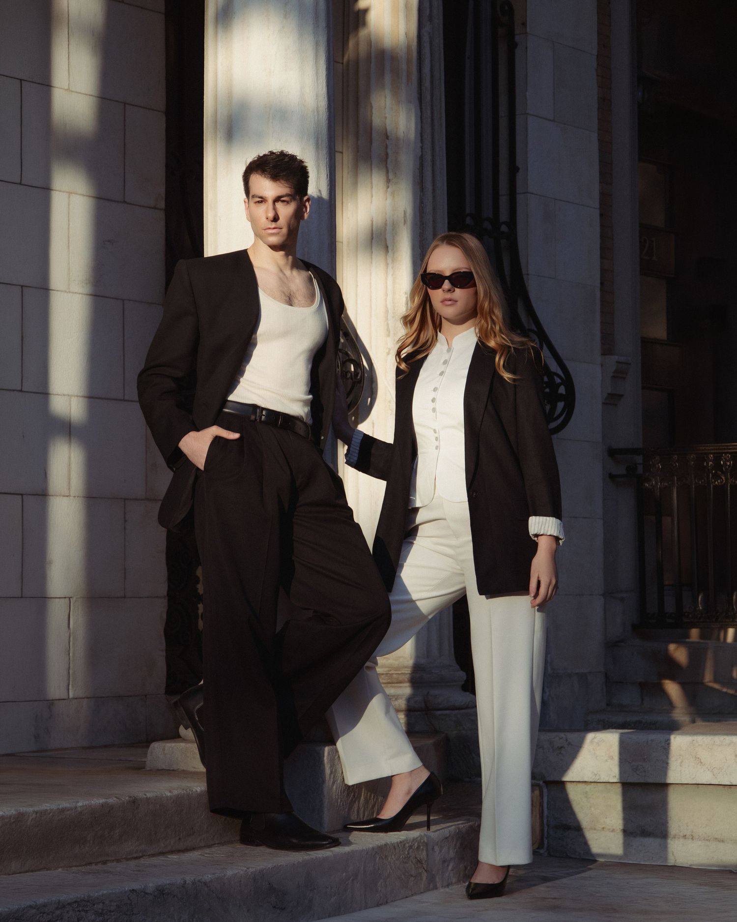 Vin and Regina pose on sunlit stone steps in contrasting black-and-white outfits on the Upper West Side.
