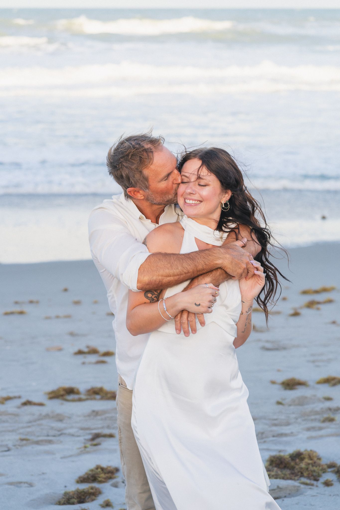 Couple embracing at sunset on Melbourne Beach engagement session