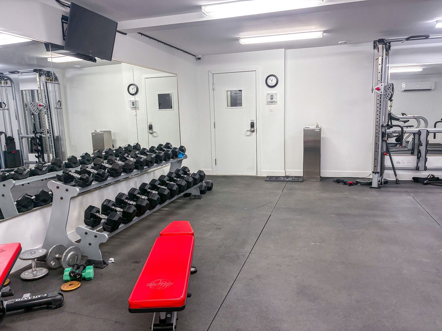 Modern fitness gym interior with weight training equipment, cardio machines and clean professional lighting in Montréal