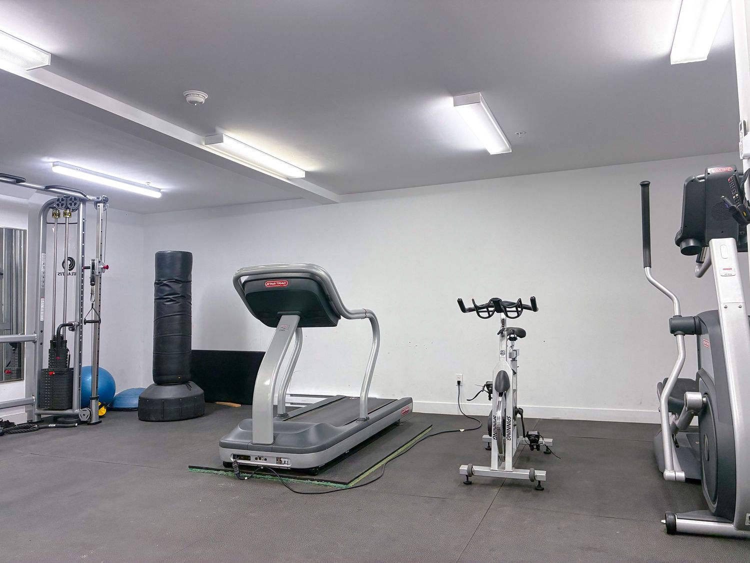 Modern fitness gym interior with weight training equipment, cardio machines and clean professional lighting in Montréal
