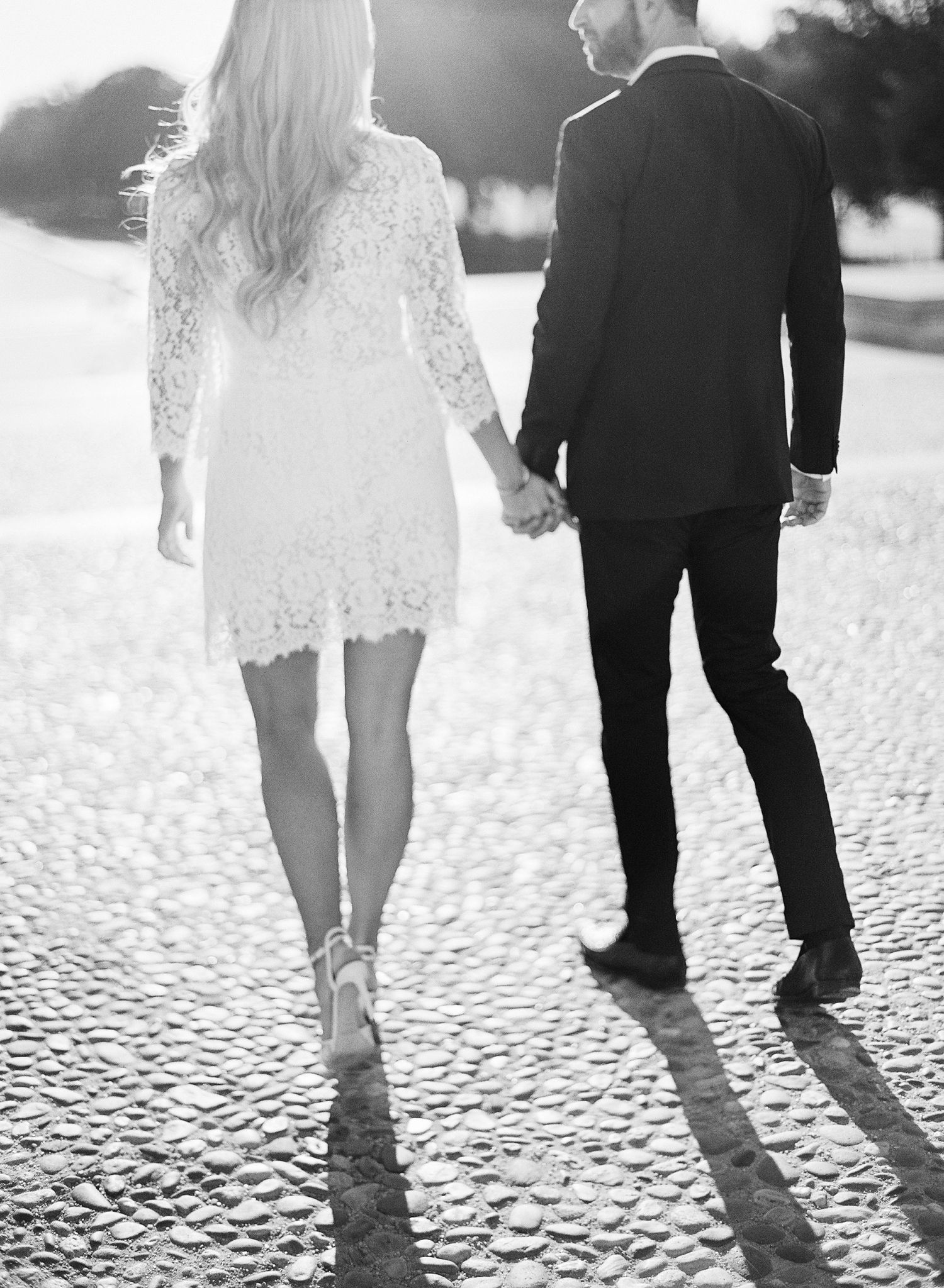 Black and white photo series of a couple walking together on cobblestone pavement, showing their legs and formal attire.