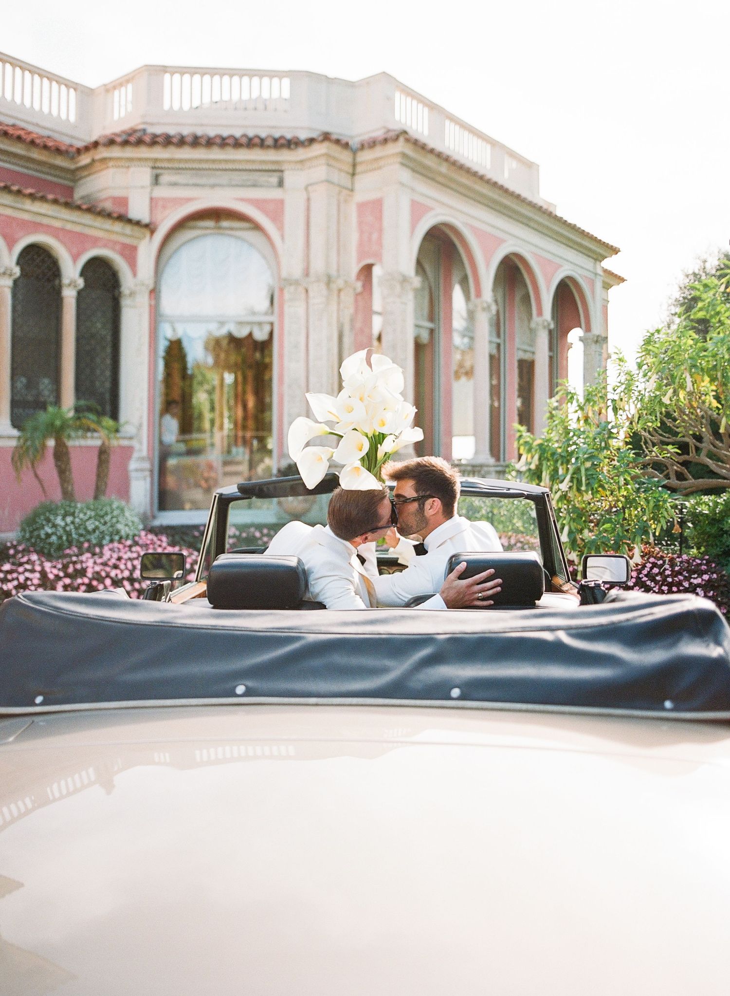 A series of romantic wedding photos taken at a Mediterranean-style venue with pink walls and arched architecture.