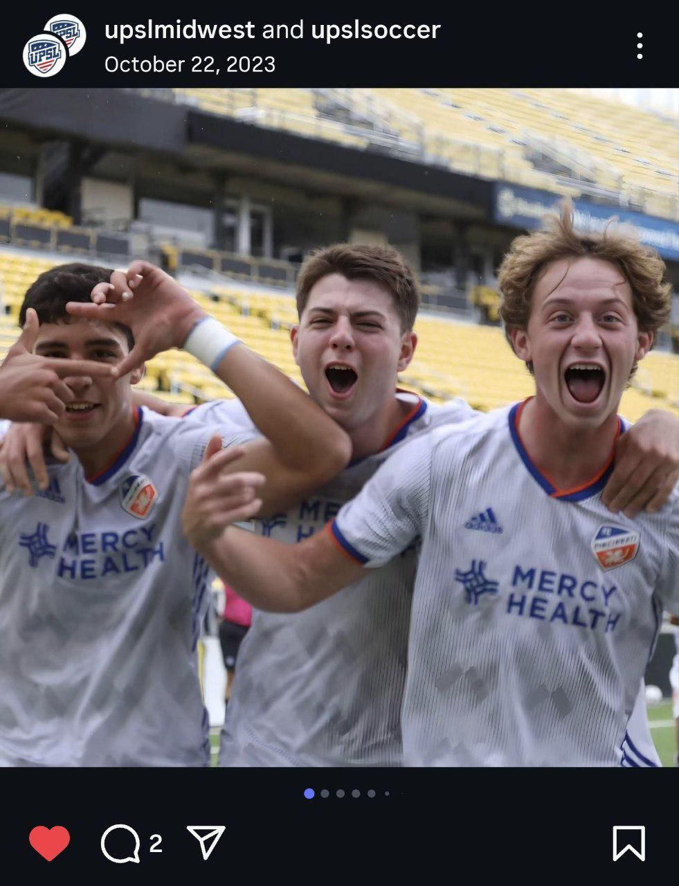 Soccer team players celebrating together in white uniforms with Mercy Health sponsorship.