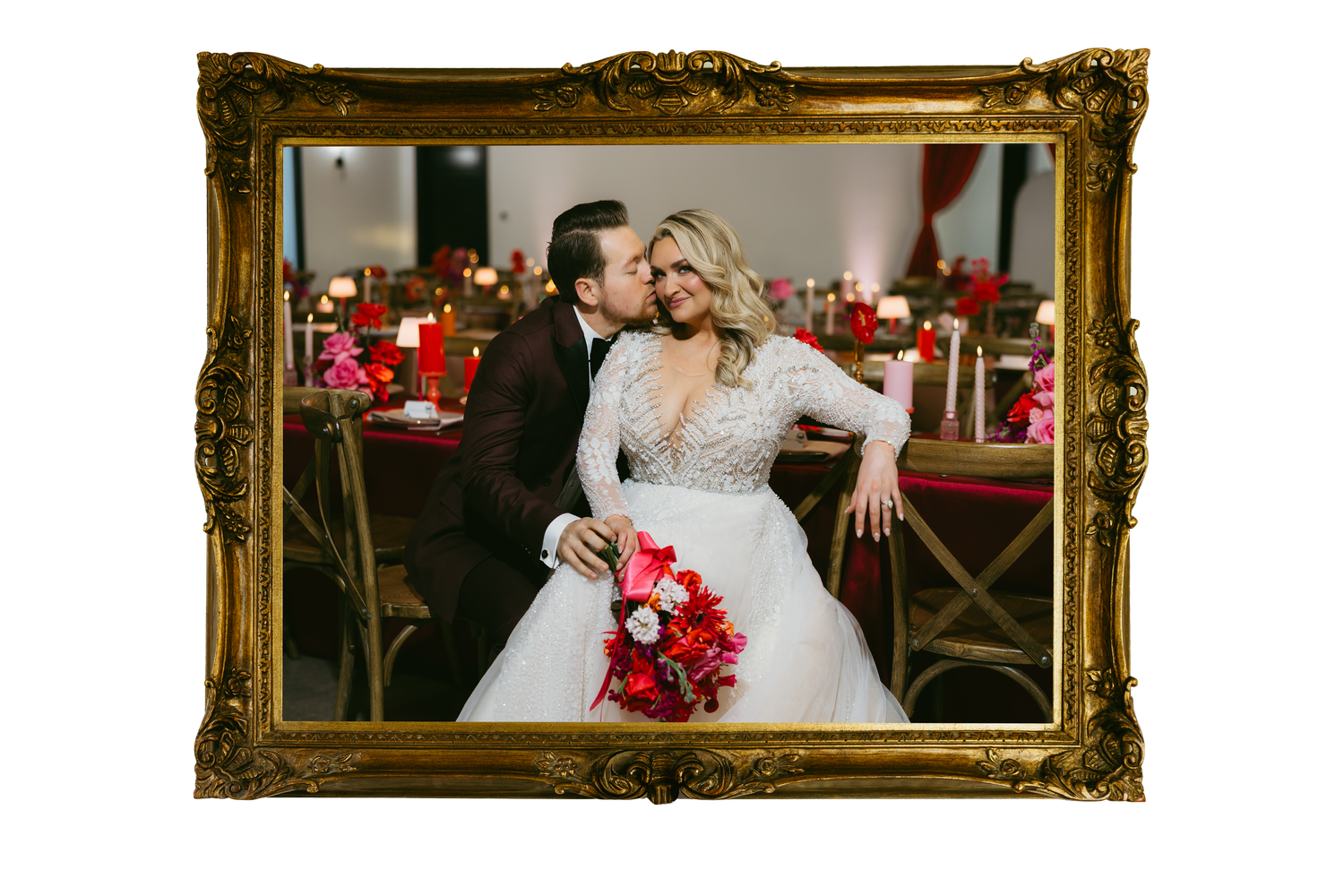 Bride and groom pose together at elegant red-themed wedding reception, bride holding vibrant pink bouquet in ornate gold frame.